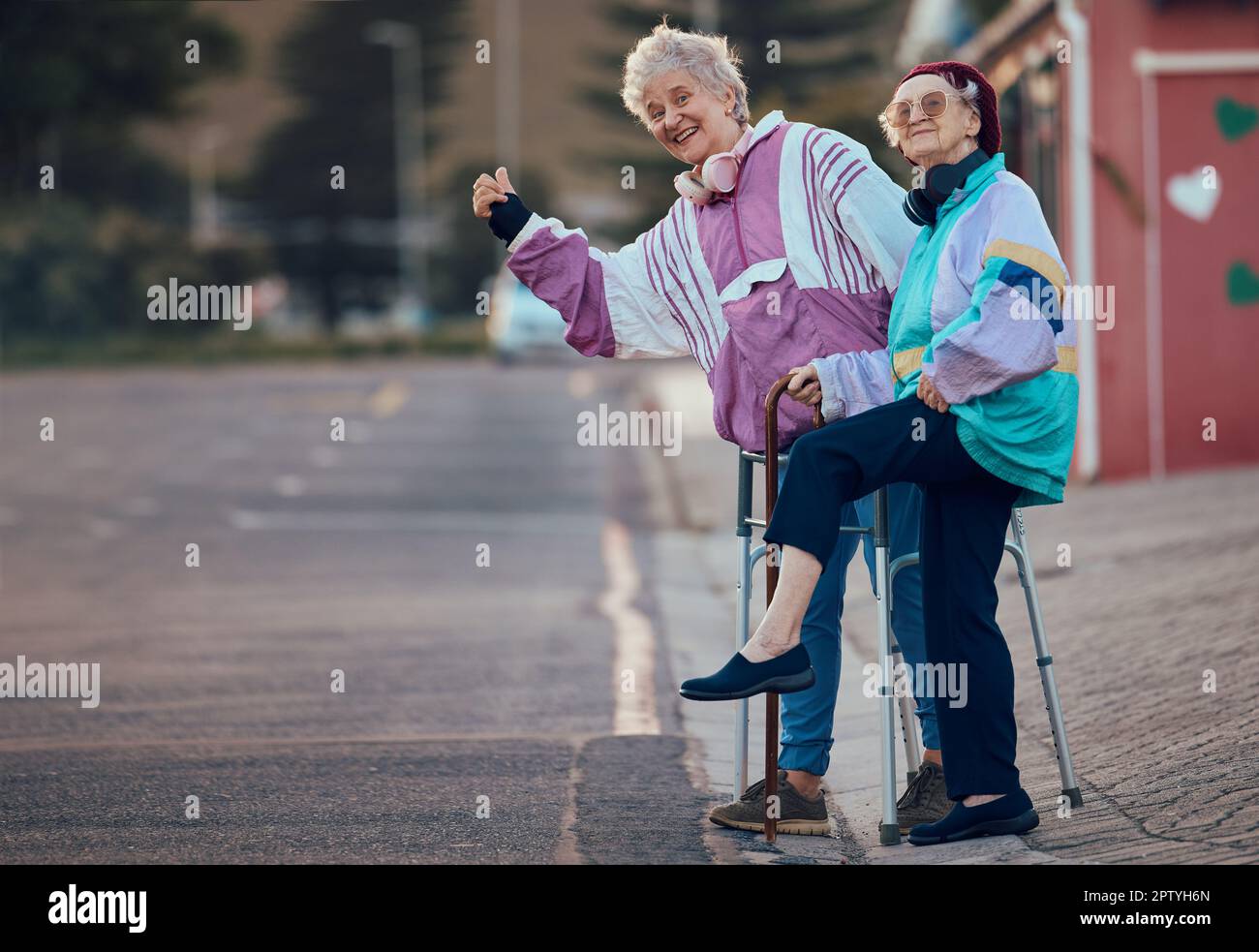 Hand, thumbs up and senior women with disability in a road for travel, fun and waiting for taxi in a city. Elderly, friends and disabled seniors hitch Stock Photo