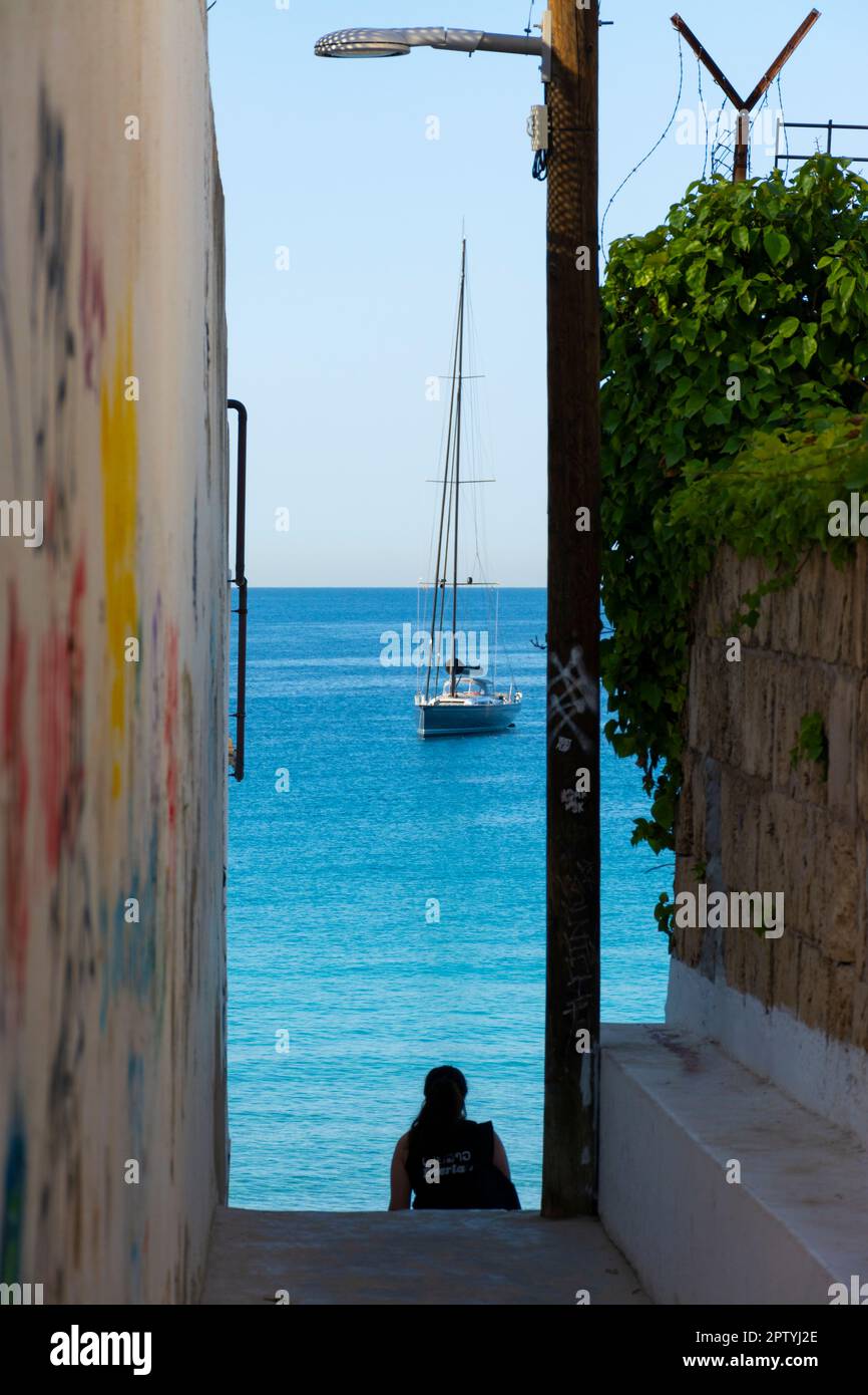 Palma, Mallorca, Spain. July 23, 2022 - Cala Major beach access with downstairs. Moored sailboat in front of the beach Stock Photo