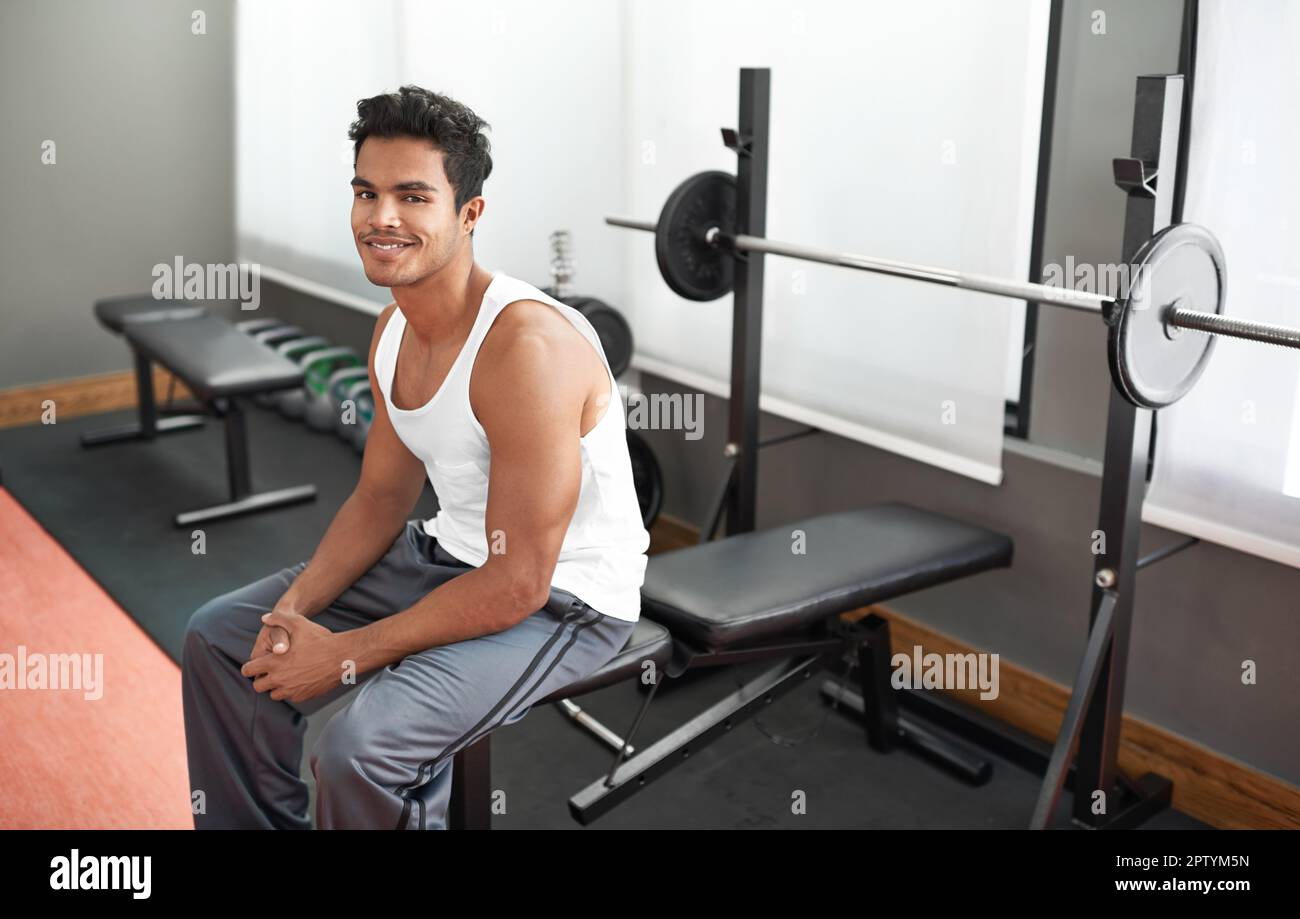This is going to be an awesome workout. A young ethnic man sitting on a weight bench at a gym Stock Photo Alamy