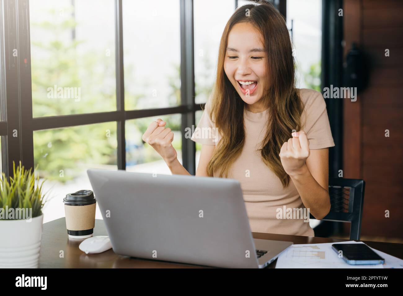 Excited happy Asian business young woman sitting with laptop computer ...