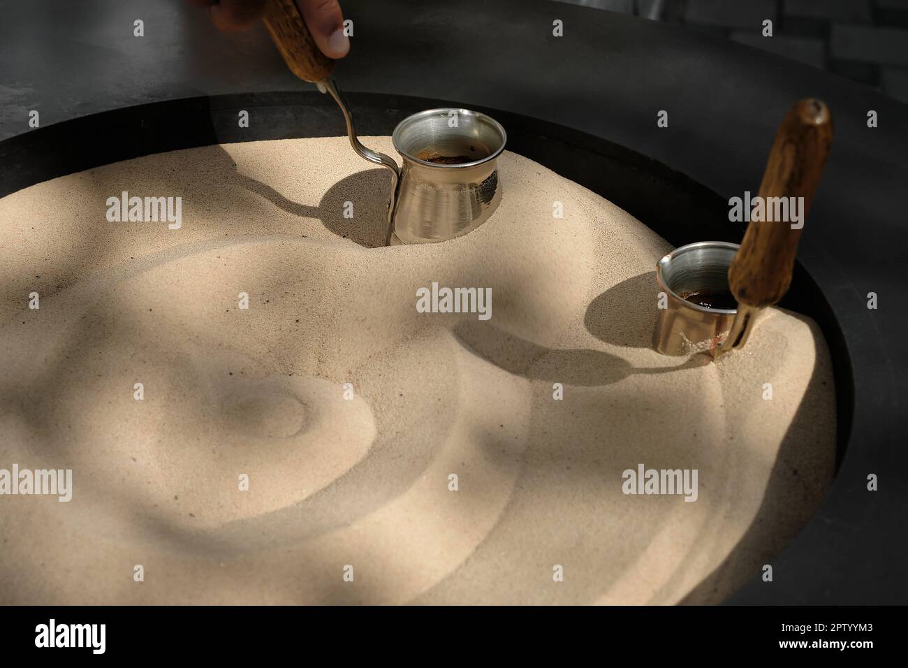 Coffee brewed on hot sand Turkish coffee brewed in a Turk, closeup