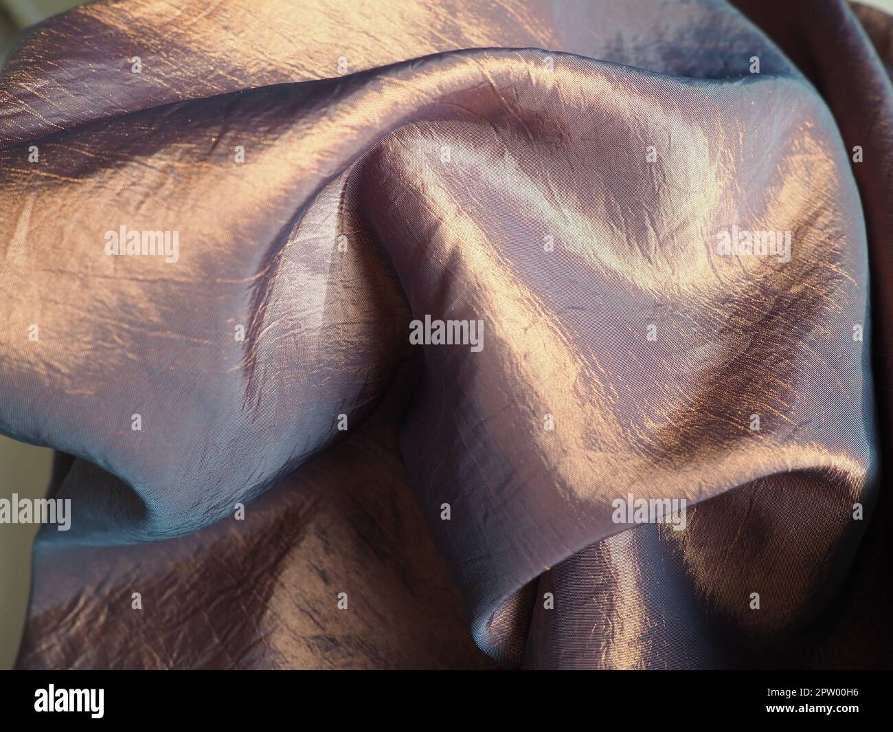 Beautiful fabric - taffeta, gently folded in waves. Crumpled material that looks like silk or brocade. Overflow and color gradient at different lighti Stock Photo