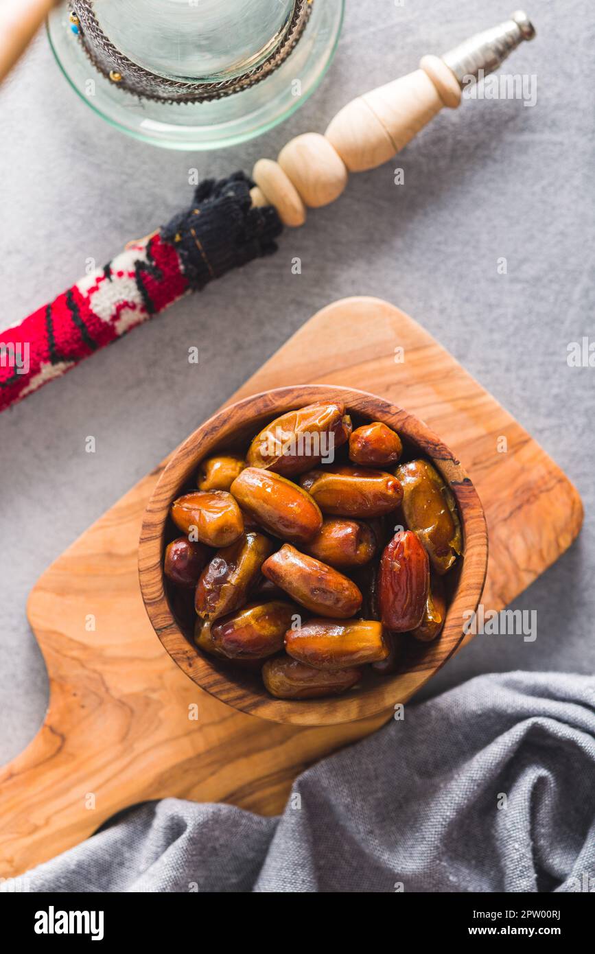 Dried dates fruit in the wooden bowl. Top view Stock Photo - Alamy