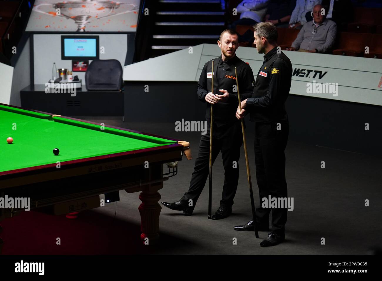 Mark Allen and Mark Selby (right) discuss the score during their match on day fourteen of the Cazoo World Snooker Championship at the Crucible Theatre, Sheffield