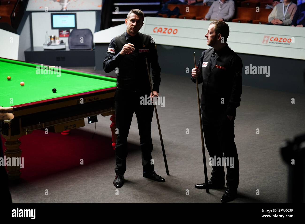 Mark Allen and Mark Selby (left) discuss the score during their match on day fourteen of the Cazoo World Snooker Championship at the Crucible Theatre, Sheffield