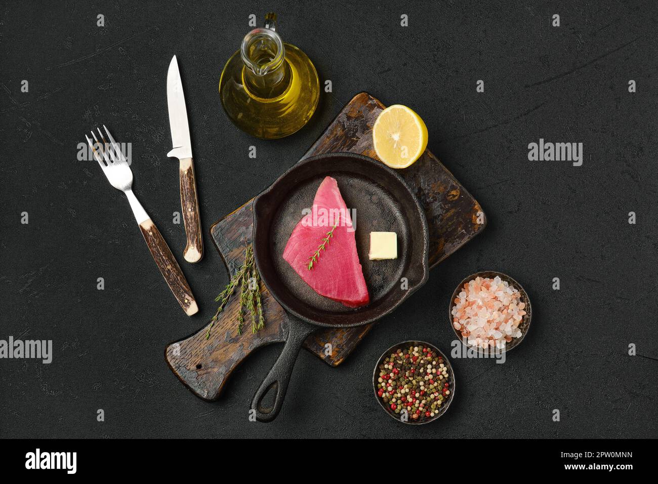 Top view of raw fresh tuna steak in cast iron skillet and spices Stock