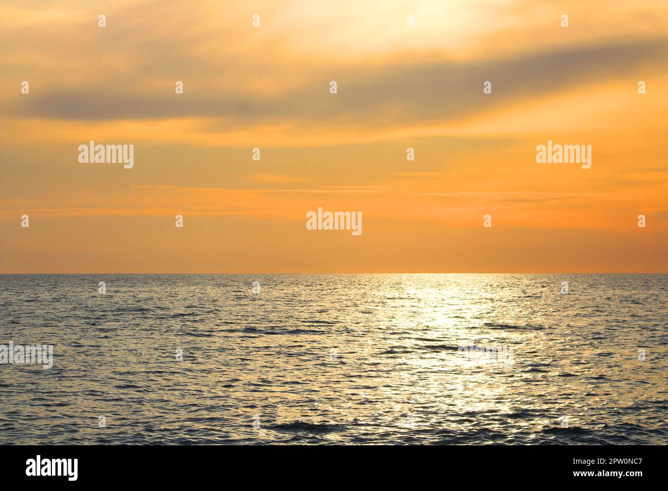 Beautiful sunset landscape at Mediterranean sea and orange sky above it with awesome sun golden reflection on calm waves. Amazing summer sunset view o Stock Photo