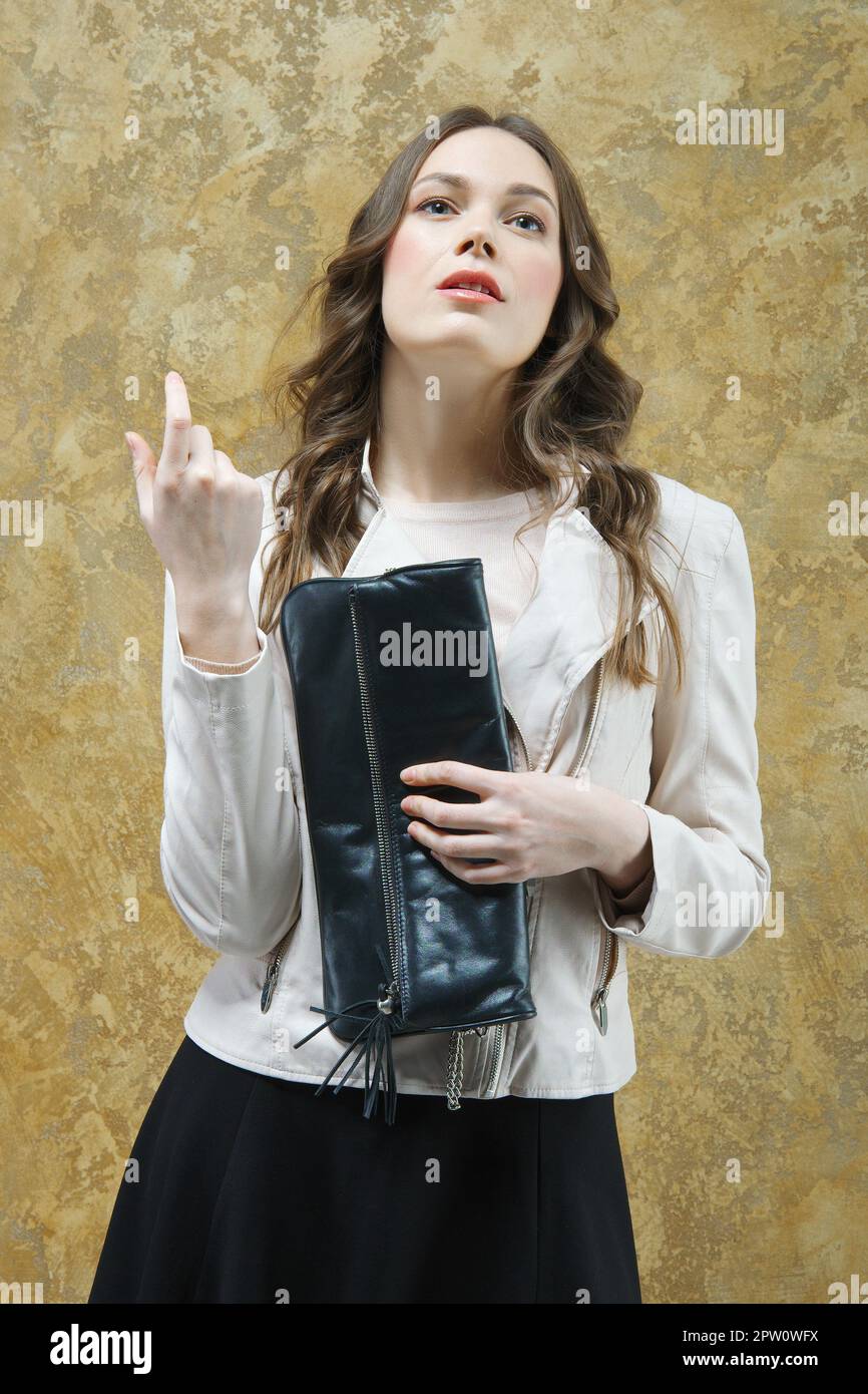 Atractive lady in white leather jacket and short black skirt Stock Photo