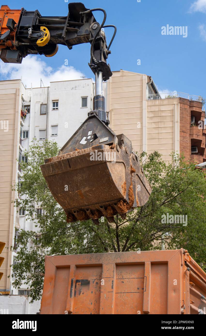 Hydraulic bucket excavator shovel moving and releasing earth in truck