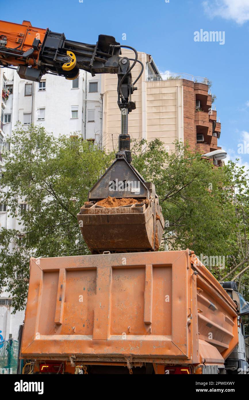 Hydraulic bucket excavator shovel moving and releasing earth in truck