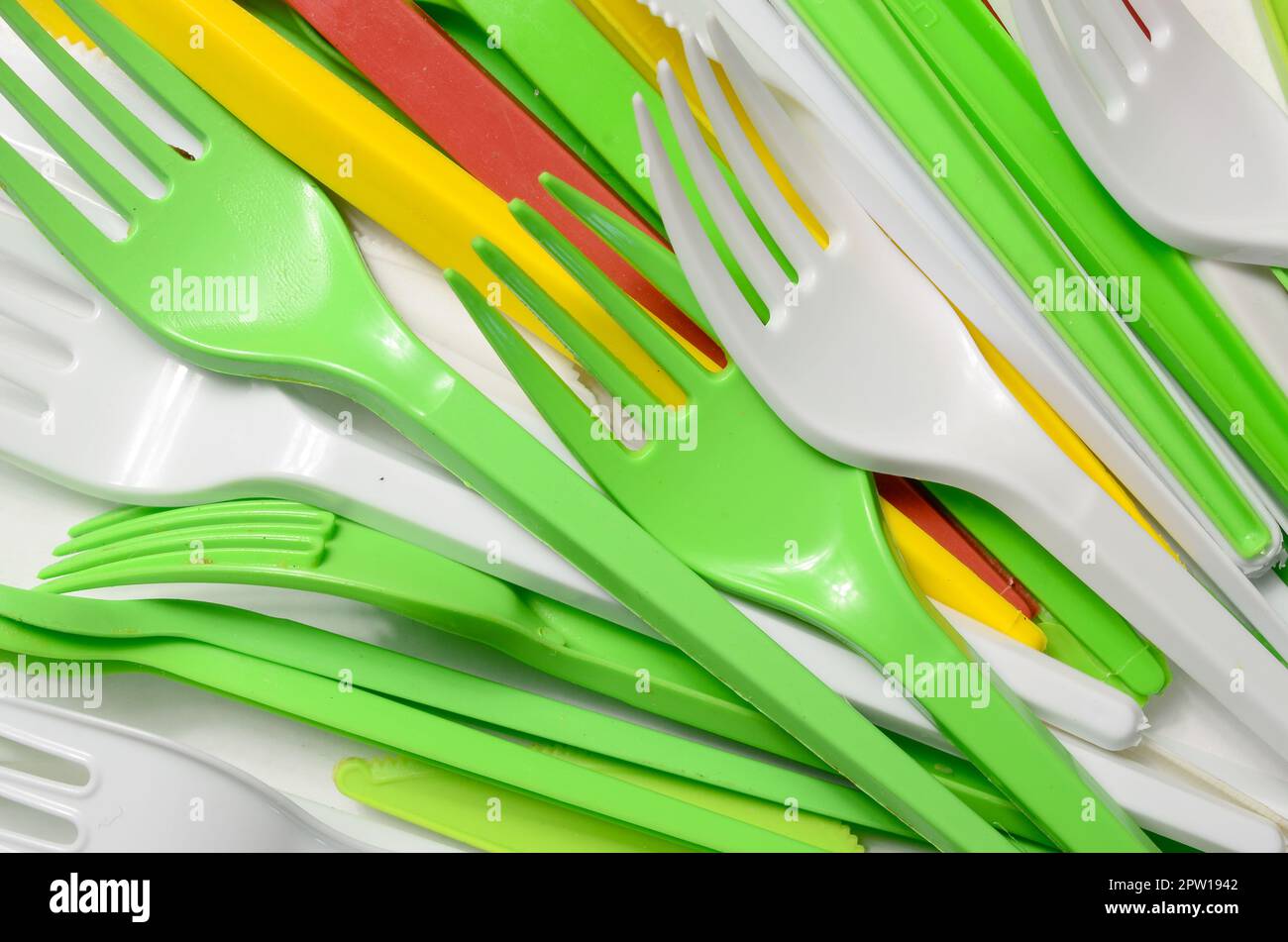 Pile of bright yellow, green and white used plastic kitchenware