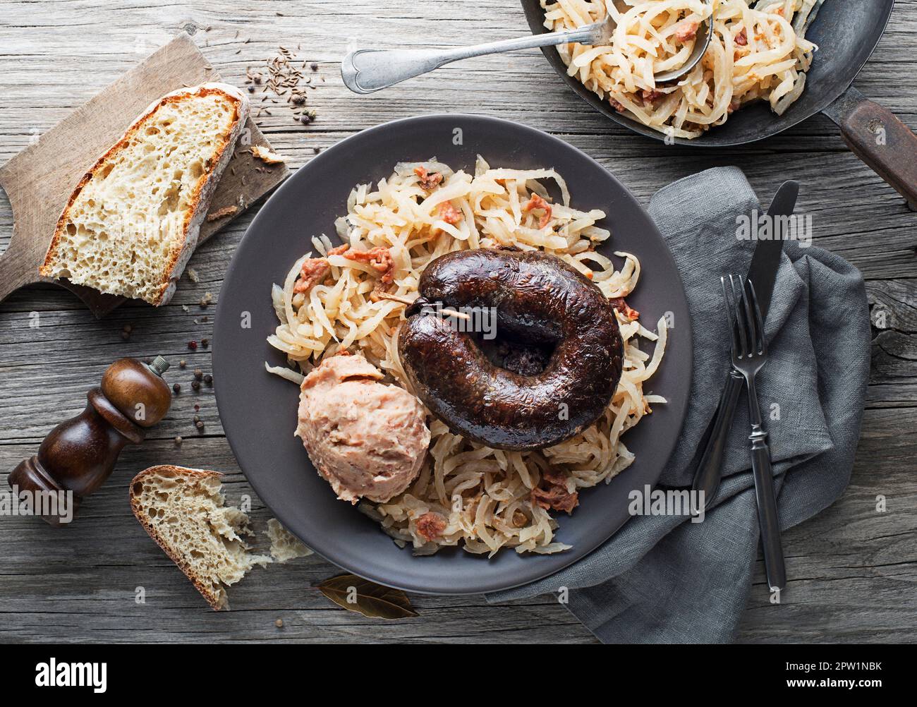 Bloody sausage morcilla, stewed sauer turnip and mashed potato with brown beans close up. Traditional Slovenian dish with roasted bloody sausage Stock Photo