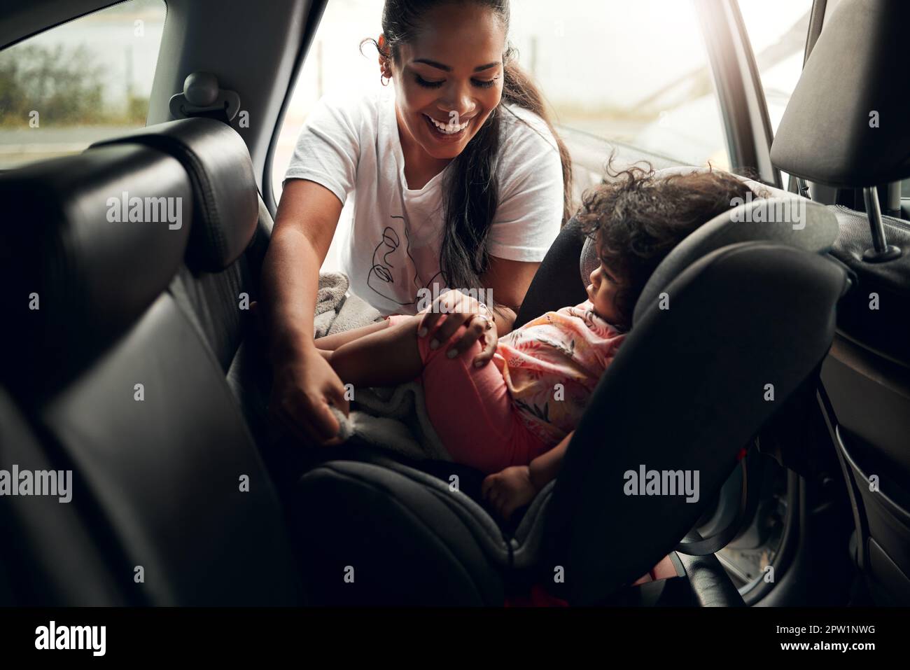 Rides always calm her down. a woman putting her baby into its car seat