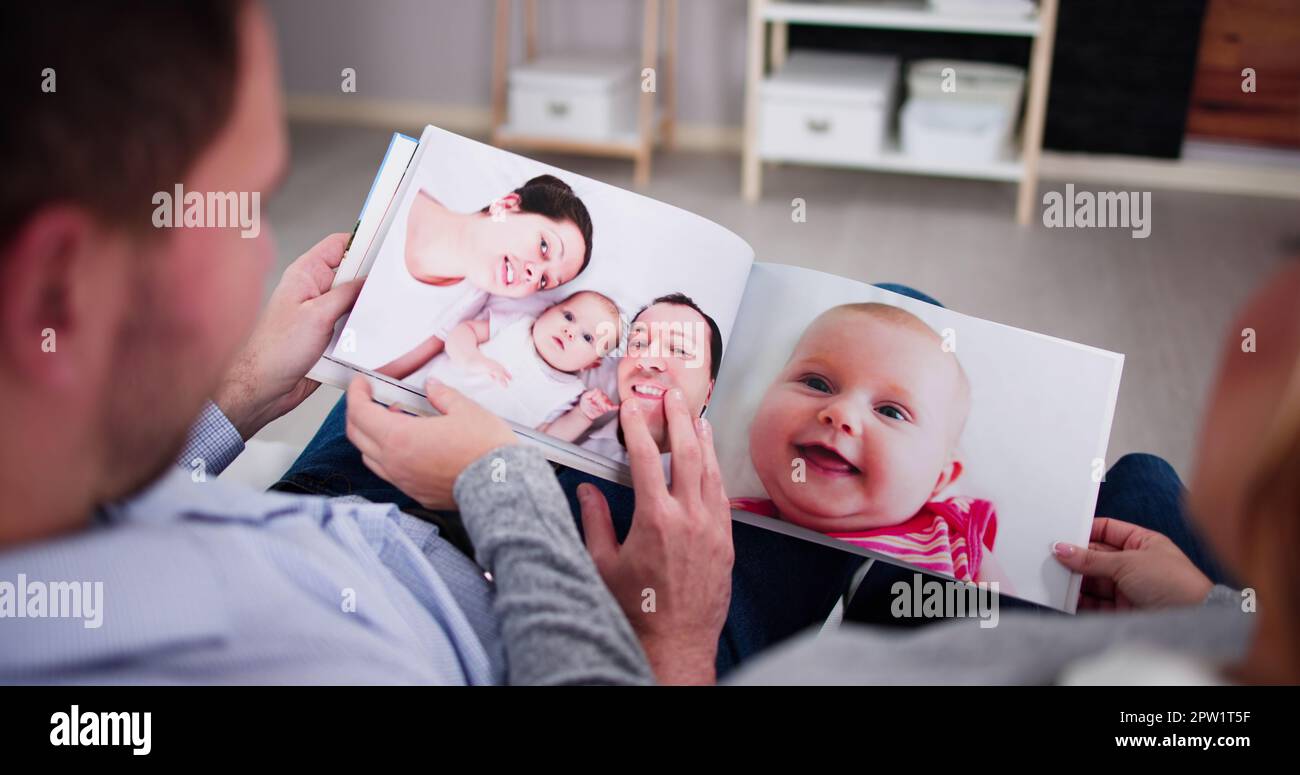 two pregnant women looking ultrasound photo album in living room Stock  Photo