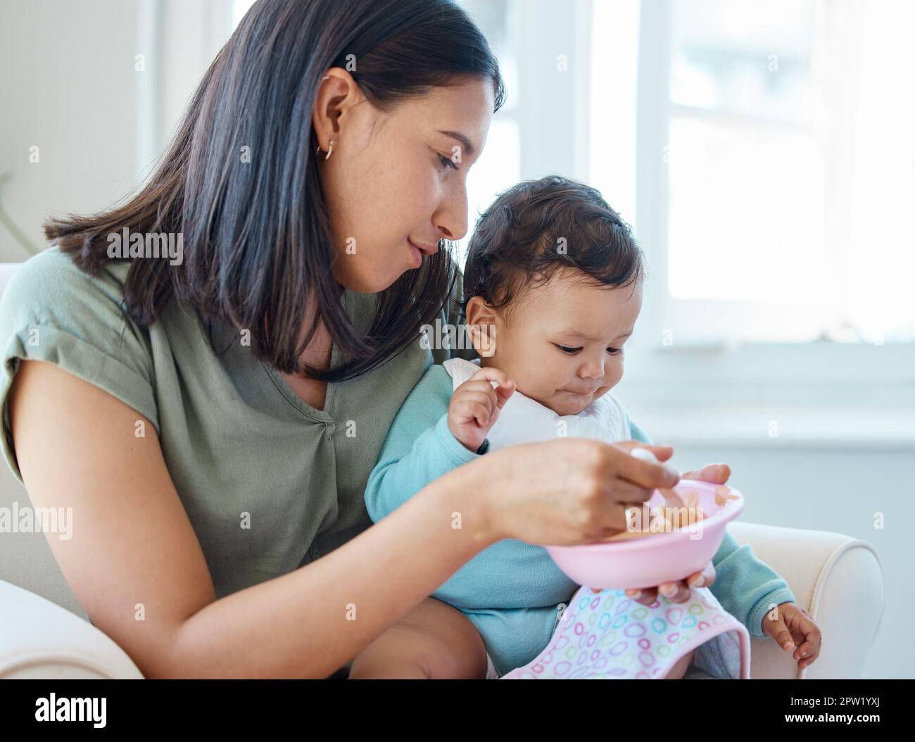 Its Time For Lunch A Mother Feeding Her Baby While Sitting On A Chair Its time for lunch a mother feeding her baby while sitting on a chair