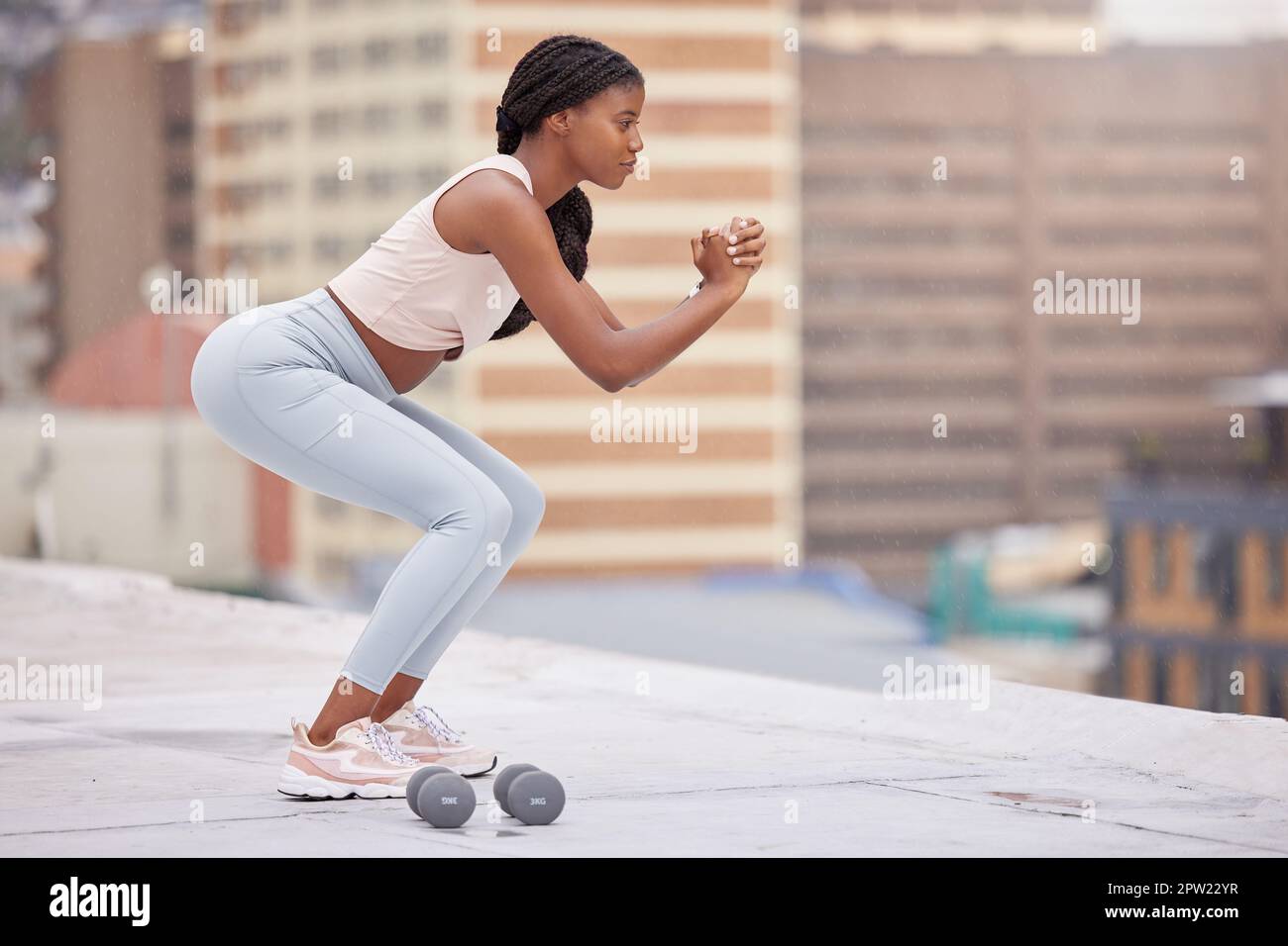 Black woman, fitness and squat training on rooftop for exercise ...