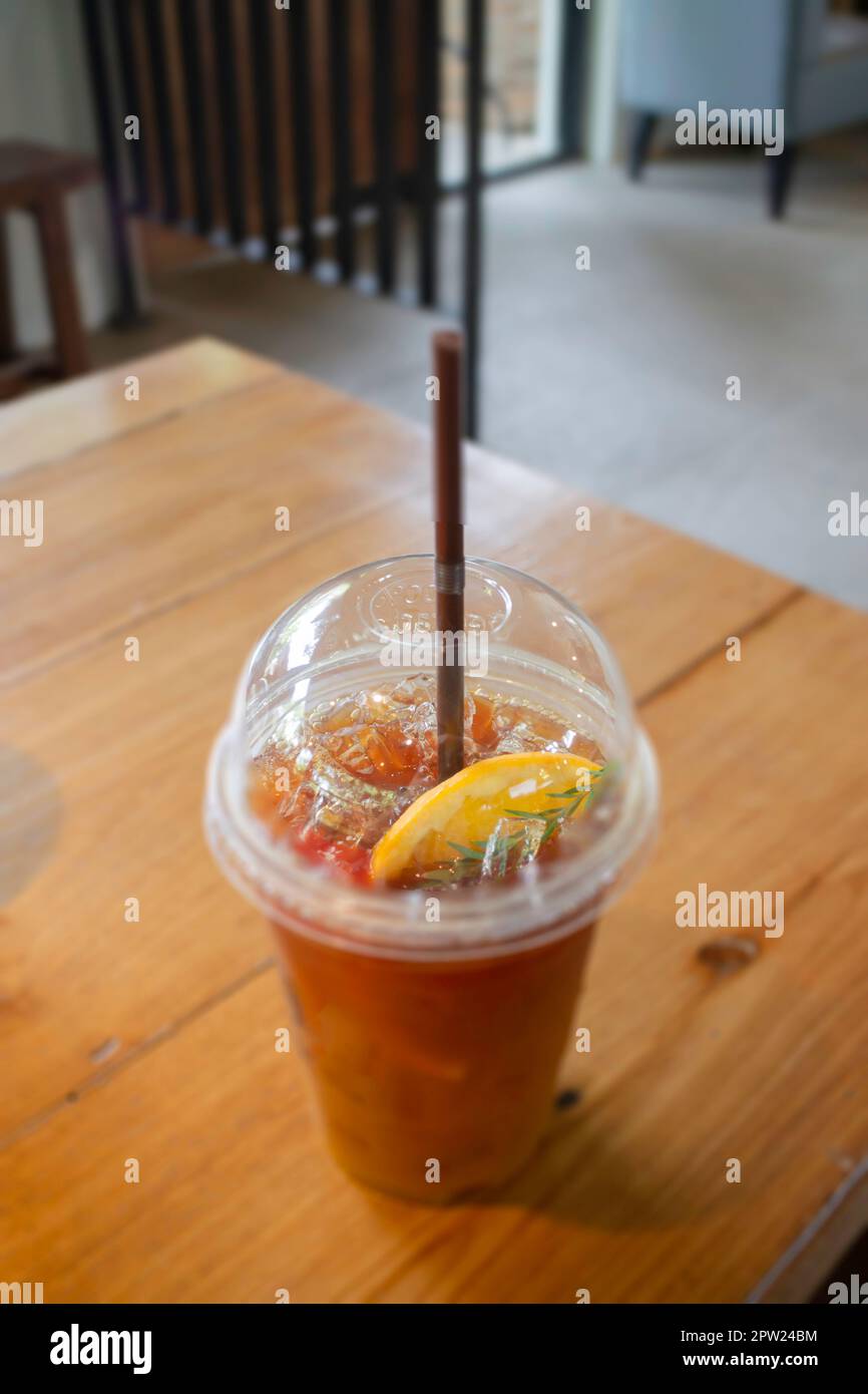 https://c8.alamy.com/comp/2PW24BM/iced-lemon-tea-in-plastic-cup-on-wooden-table-stock-photo-2PW24BM.jpg