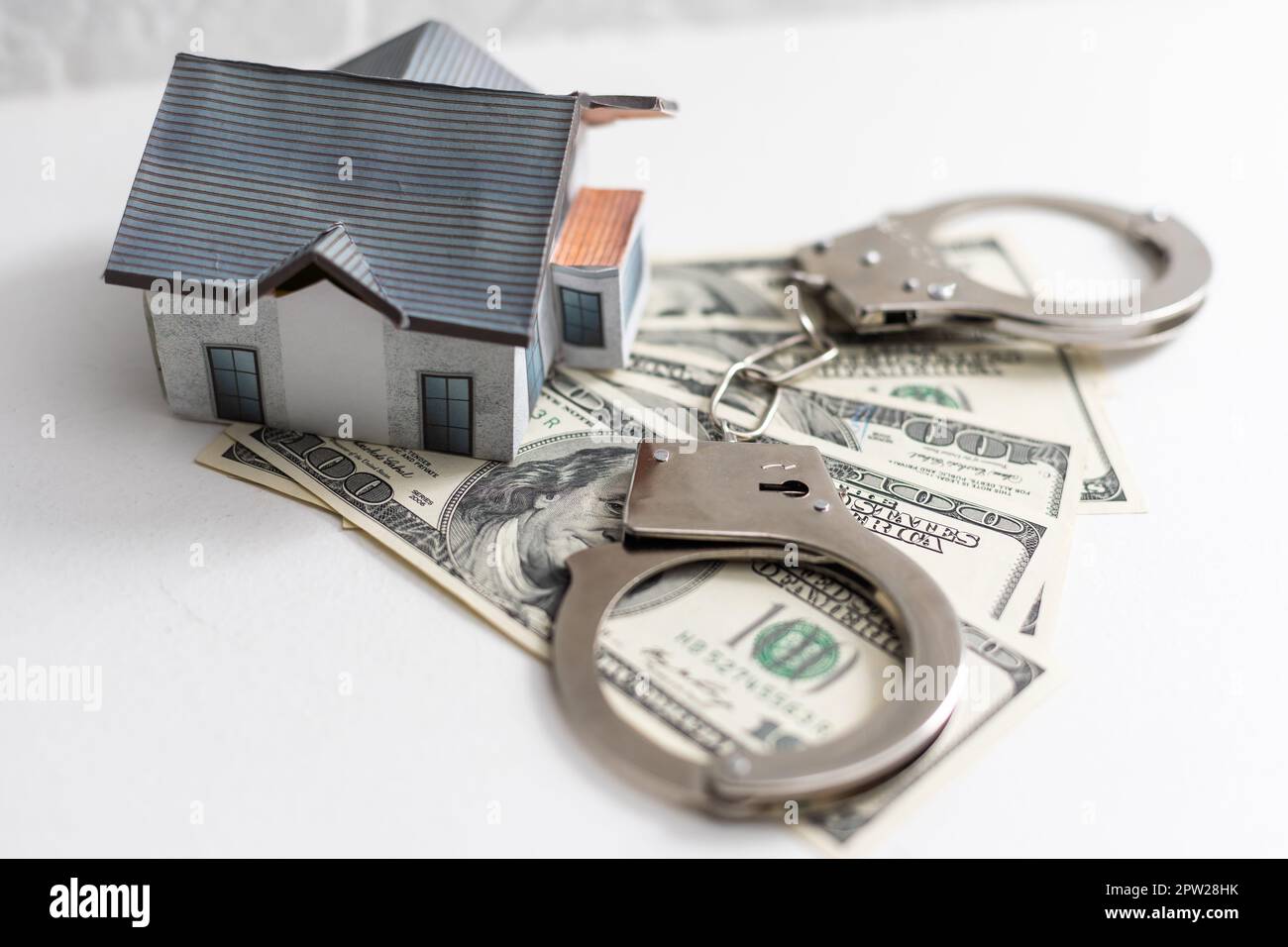 Money dollars, handcuffs toy house Stock Photo - Alamy