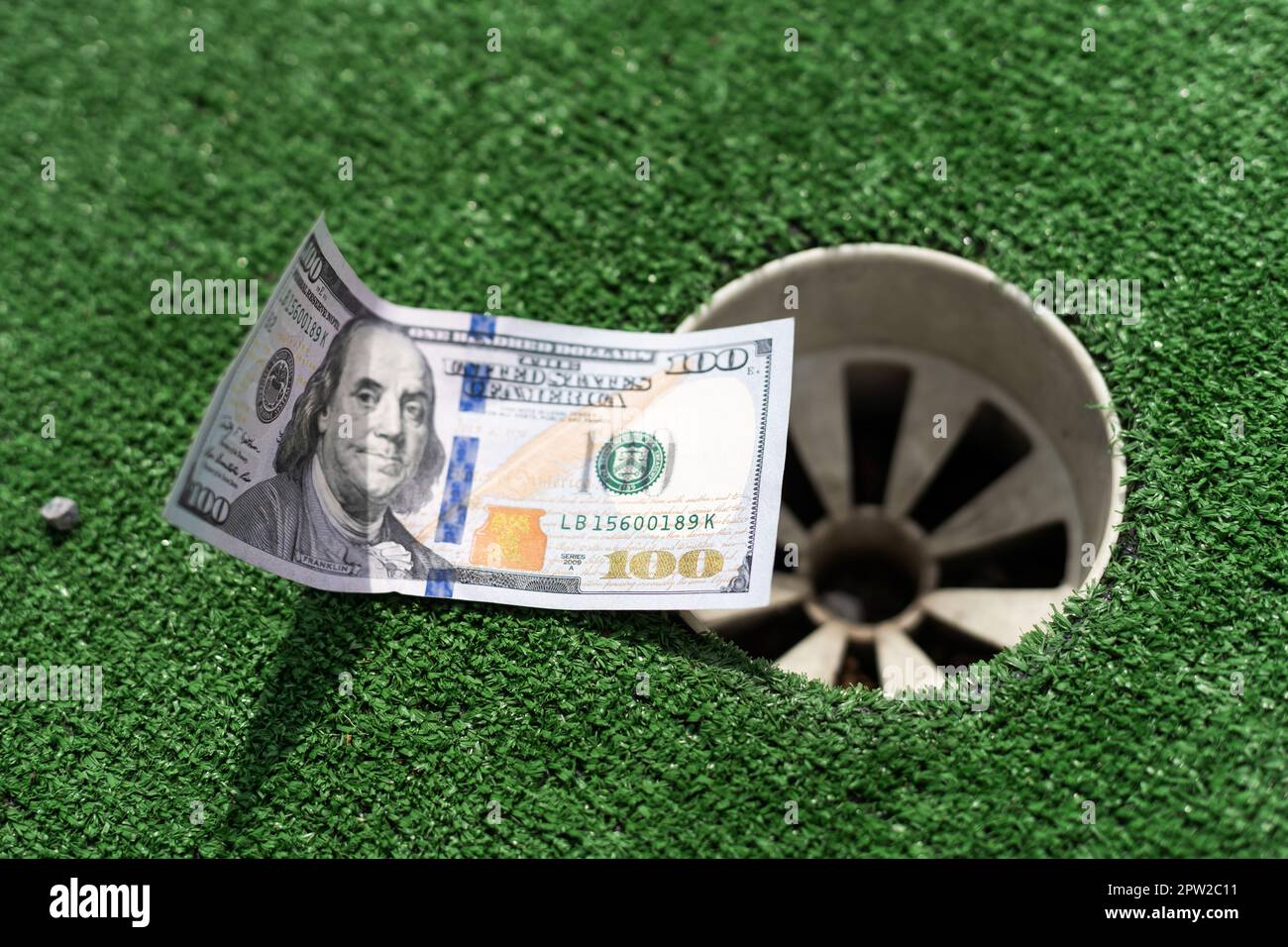 Mini Golf club, money on the artificial grass Stock Photo