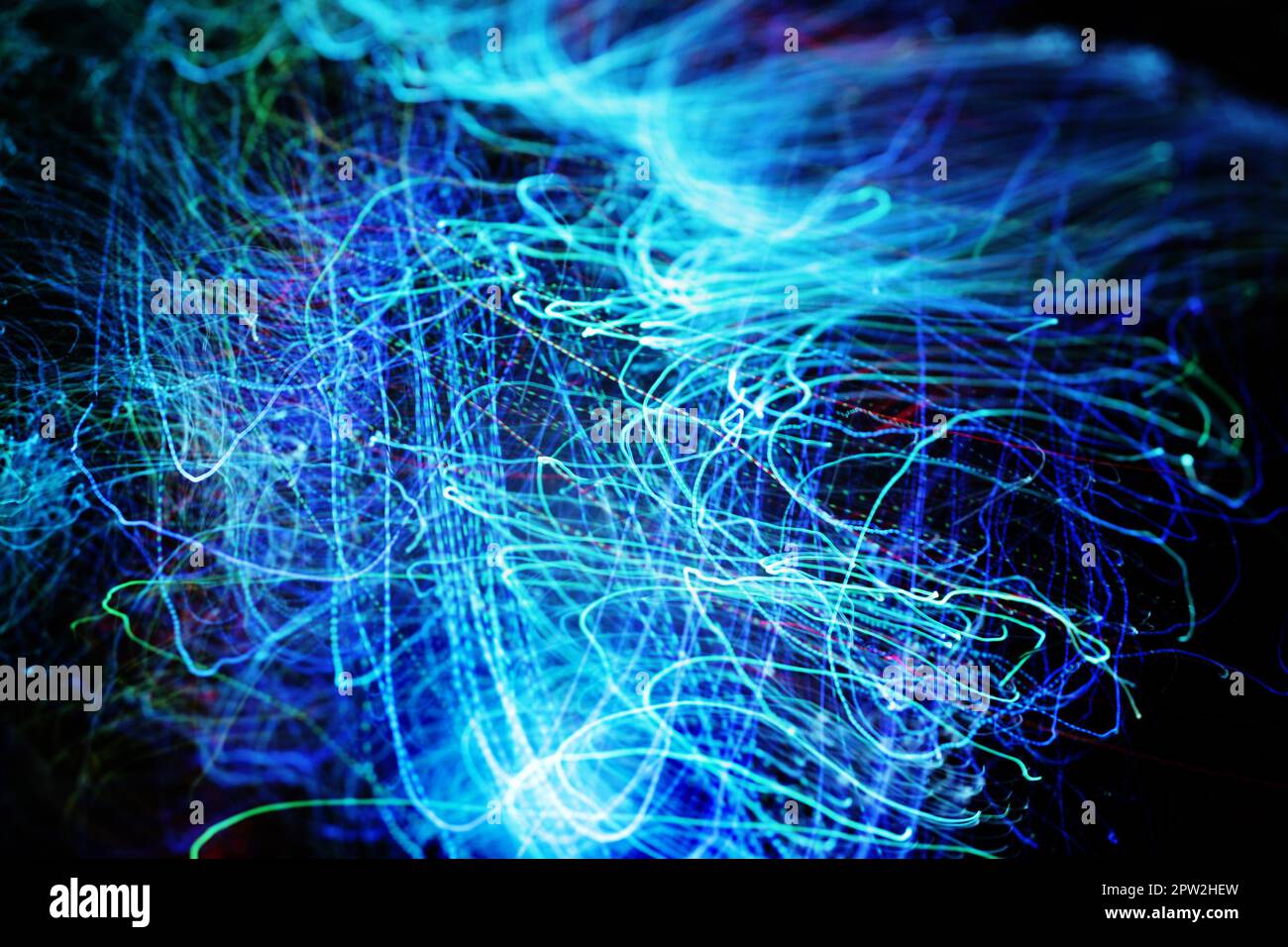 Long exposure of fiber optical light cables in LED neon blue glow. Optics with spiral motion effects for fast data, network and internet usage. Digita Stock Photo