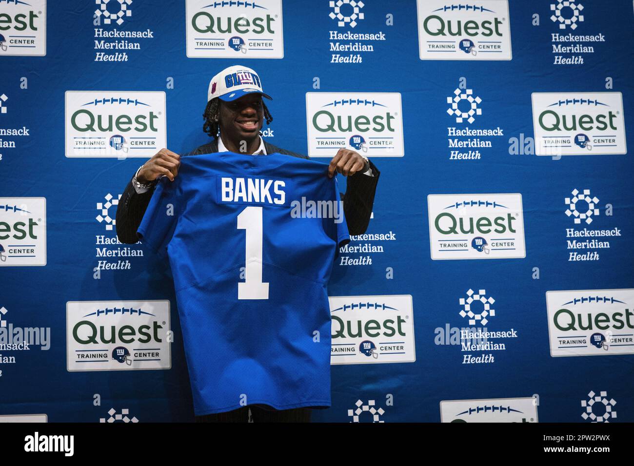New York Giants first round draft pick Deonte Banks holds up a Giants  jersey during a press conference at the NFL football team's training center  in East Rutherford, N.J., Friday, April 28,