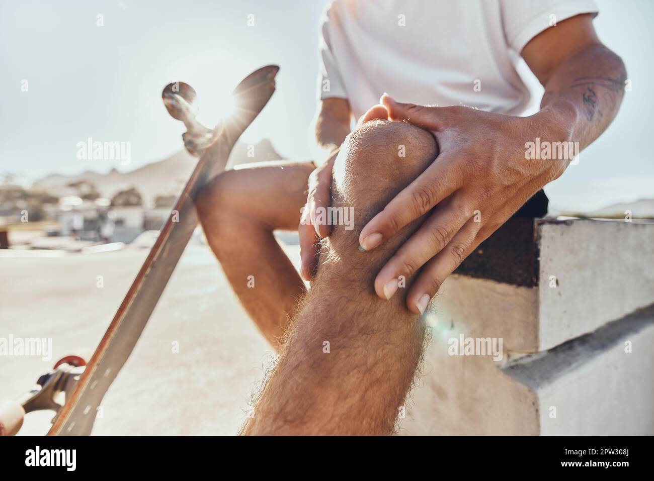 Knee pain, injury and skate accident in a skating park with training, fitness and hands holding