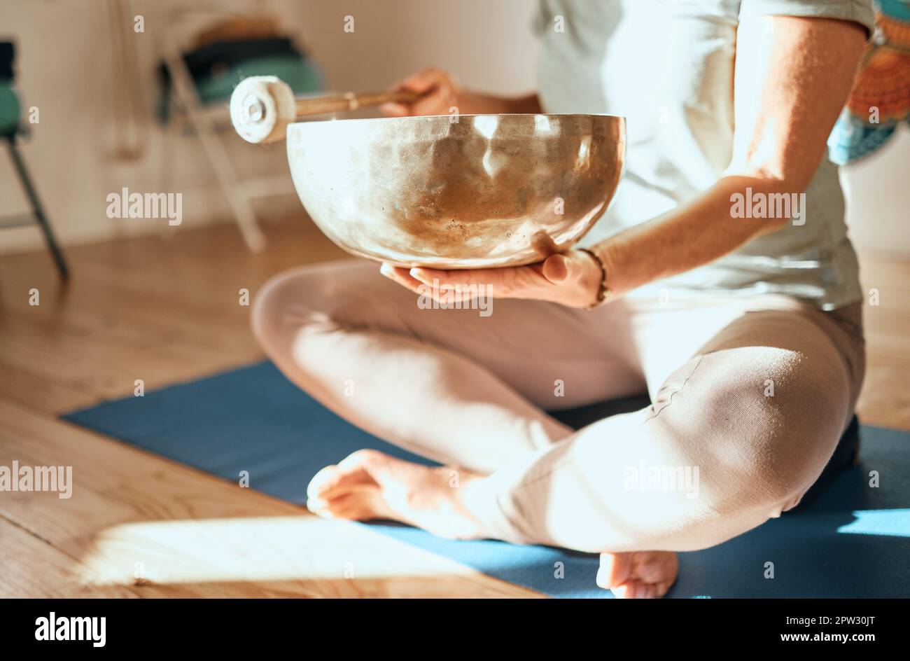 Yoga, tibetan bowl and hands of woman in meditation, sound therapy and healing with zen, ambient and peace on a floor. Wellness, singing bowl and lady Stock Photo