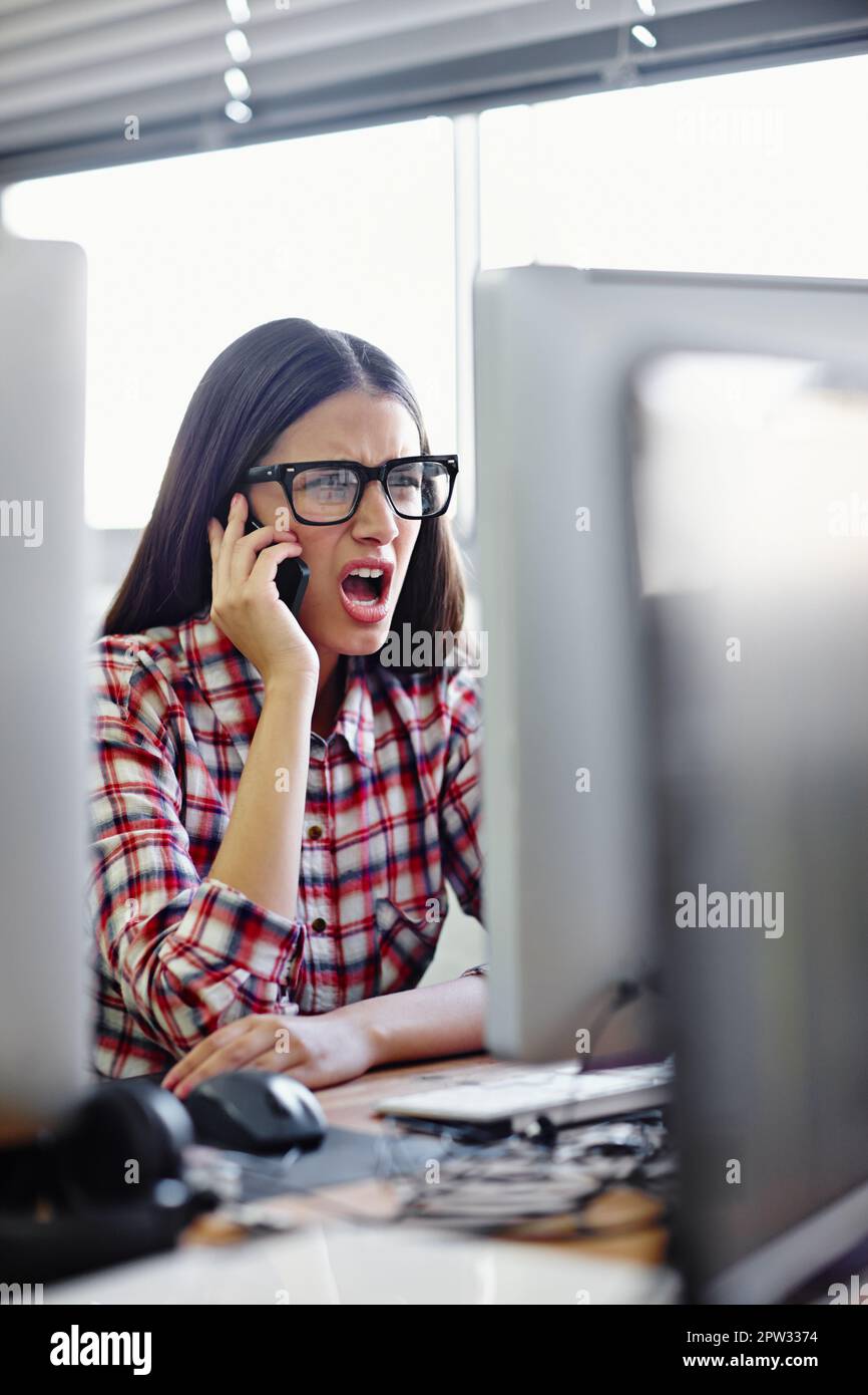 That is so rude. a young designer looking displeased while talking on her phone Stock Photo