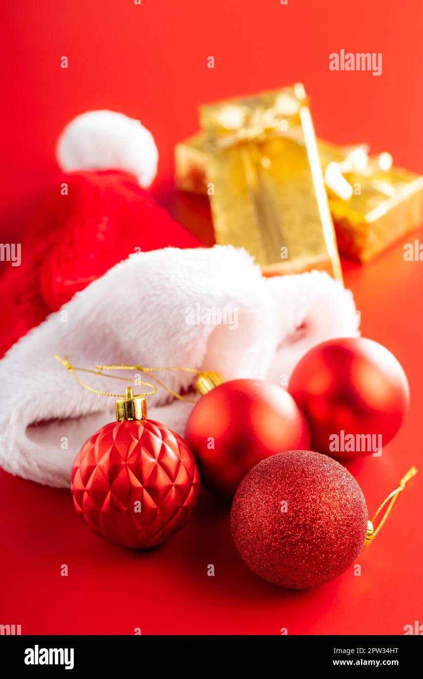Christmas balls and Santa hat. Christmas decoration on the red background. Stock Photo