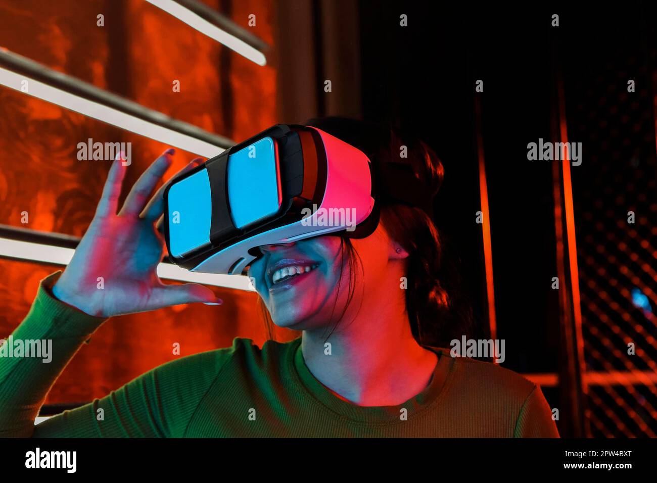 Happy female in VR headset smiling and exploring virtual reality under