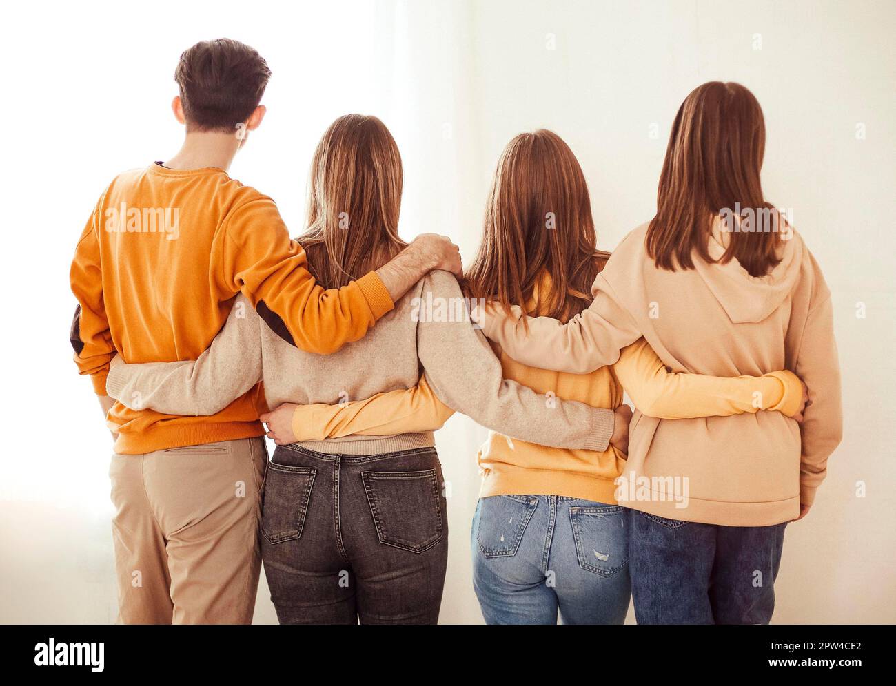 Back view of anonymous man and women embracing each other while symbolizing unity against white background Stock Photo