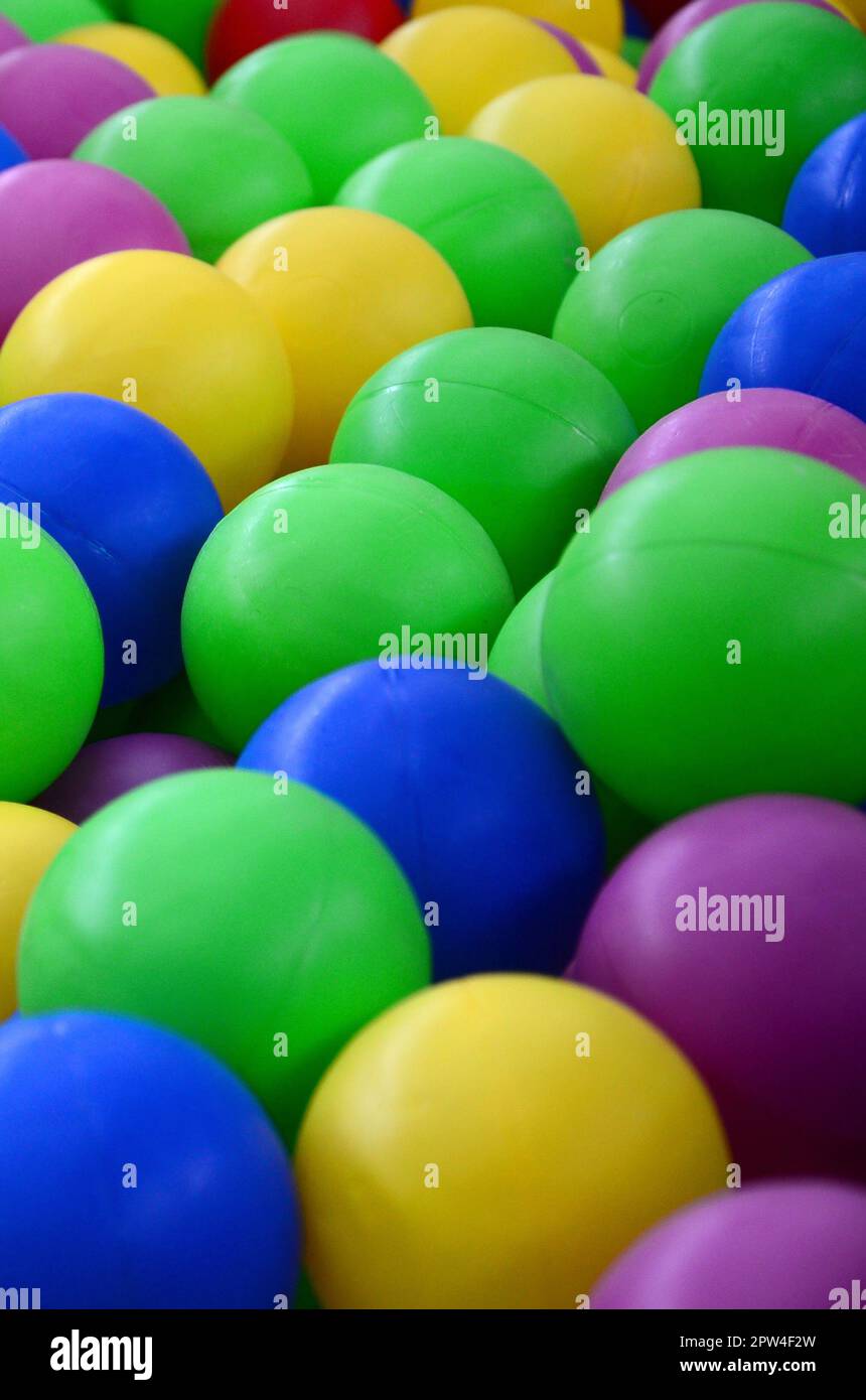 Colored plastic balls in pool of game room. Swimming pool for fun and jumping in colored plastic