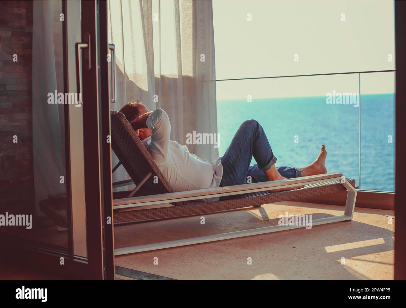 Relaxed young man at home on the balcony. Holiday and travel concept Stock Photo