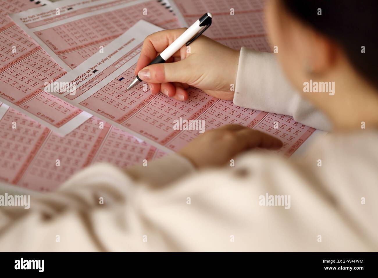 Filling out a lottery ticket. A young woman plays the lottery and ...