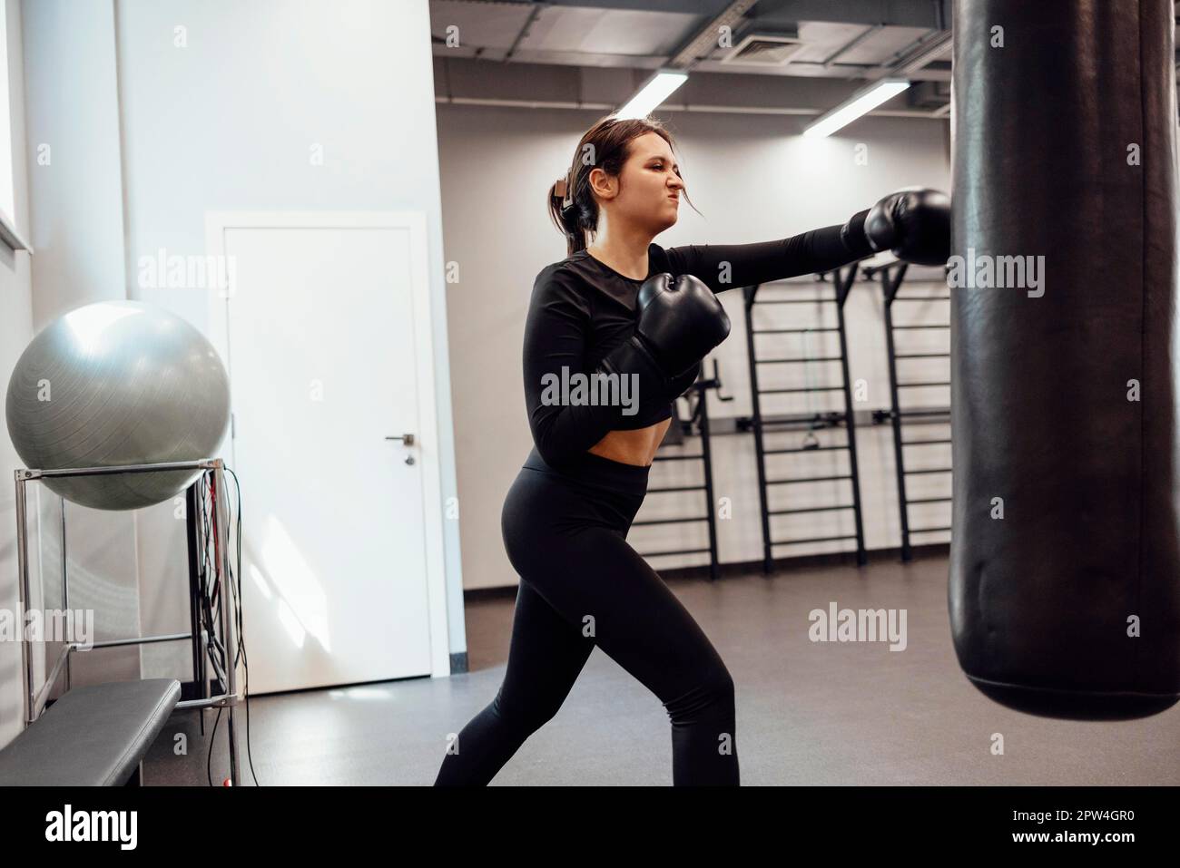 Young Asia lady kickboxing exercise workout punching bag tough female  fighter practice boxing in gym fitness class. Sportswoman recreational  activity, functional training, healthy lifestyle concept. Stock Photo