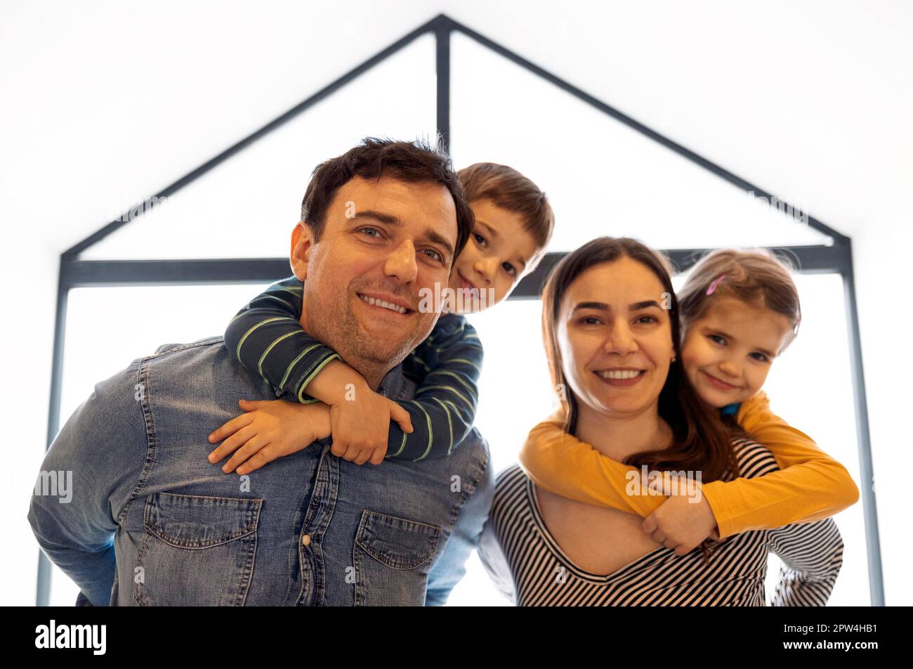 Happy parents with son and daughter posing indoors. Beautiful family ...