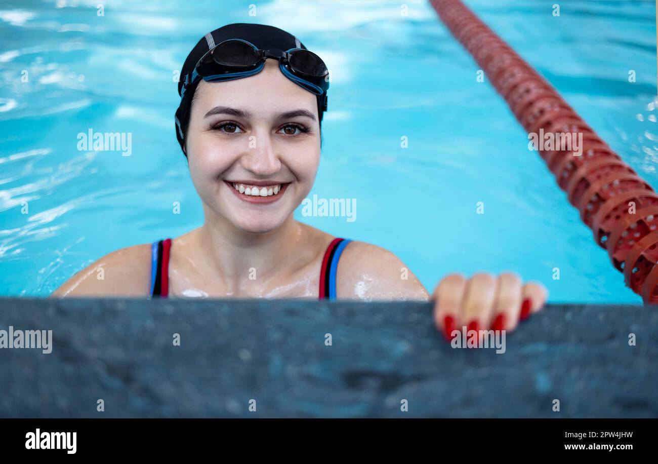Portrait of a competitive female catcher near the use. Young swimmer