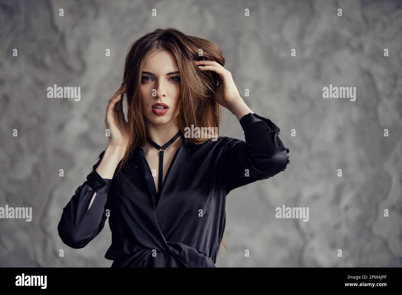 Beautiful woman touching her long hair Stock Photo - Alamy