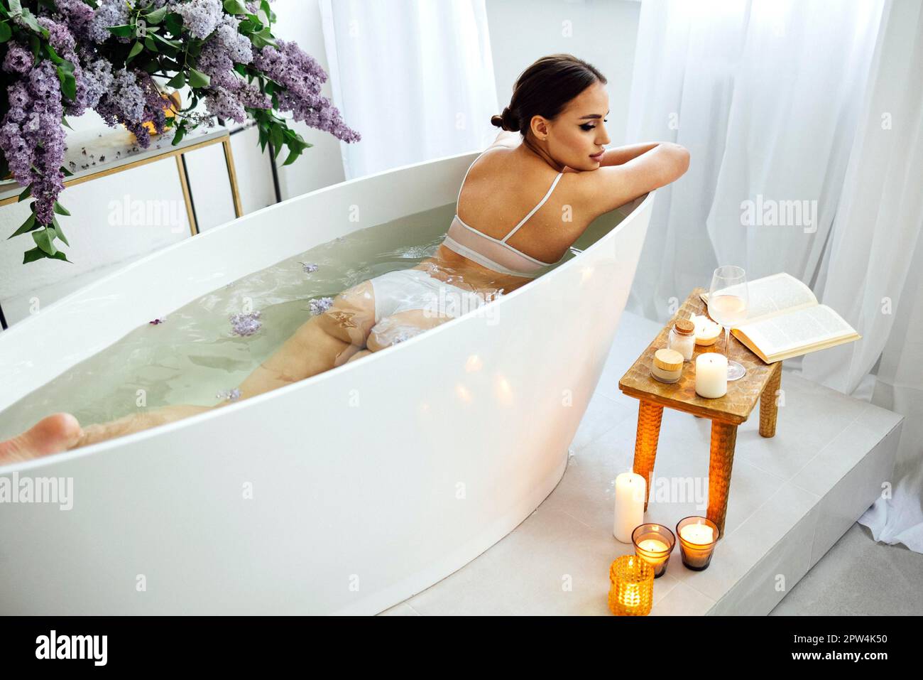 Candles in a spa bathtub. Relaxing soap suds soak. Romantic bath. Stock  Illustration