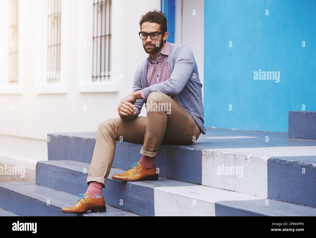 Stepping up his style. Full length shot of a stylish man sitting on a ...