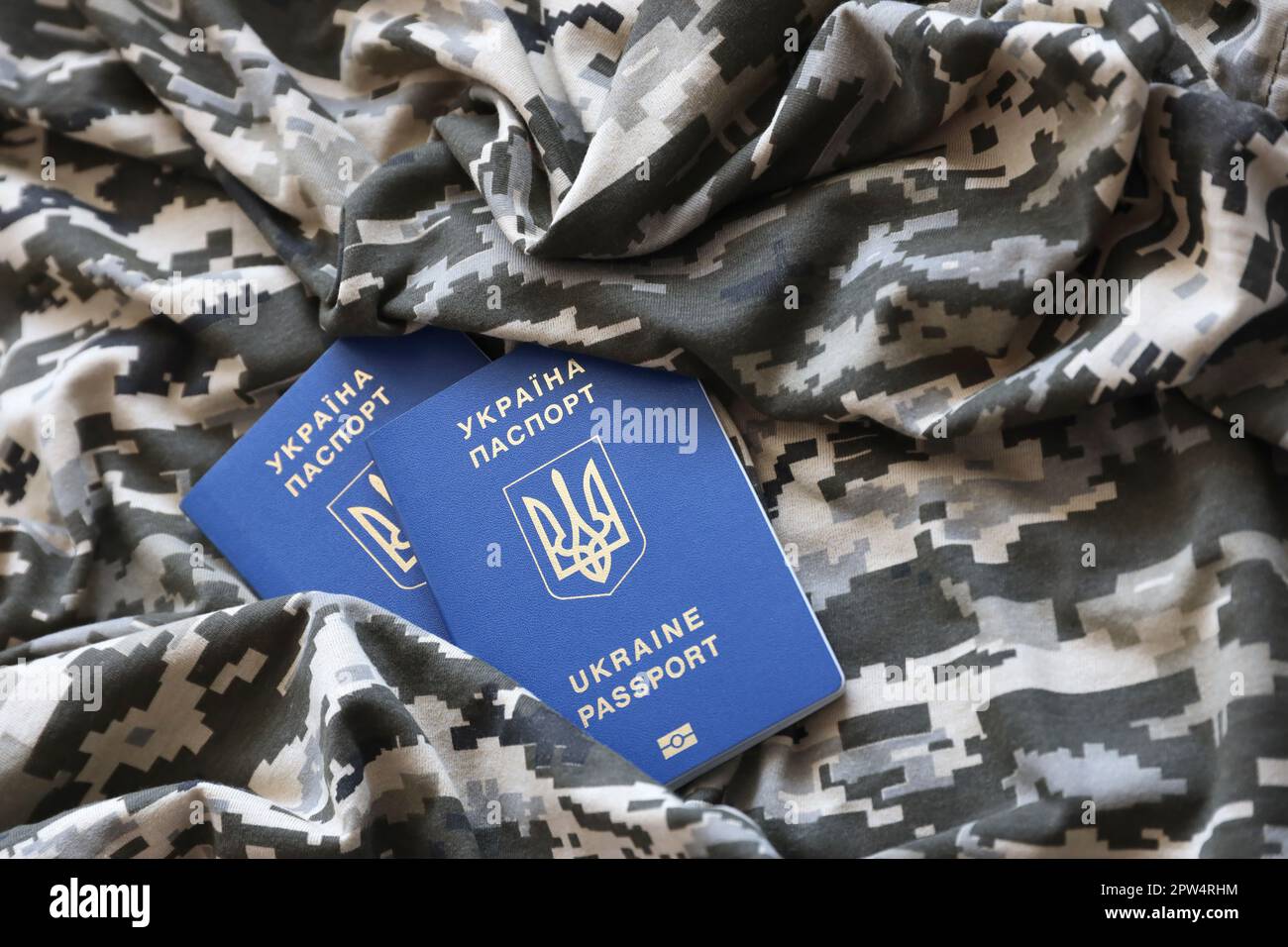 Ukrainian foreign passport on fabric with texture of military pixeled