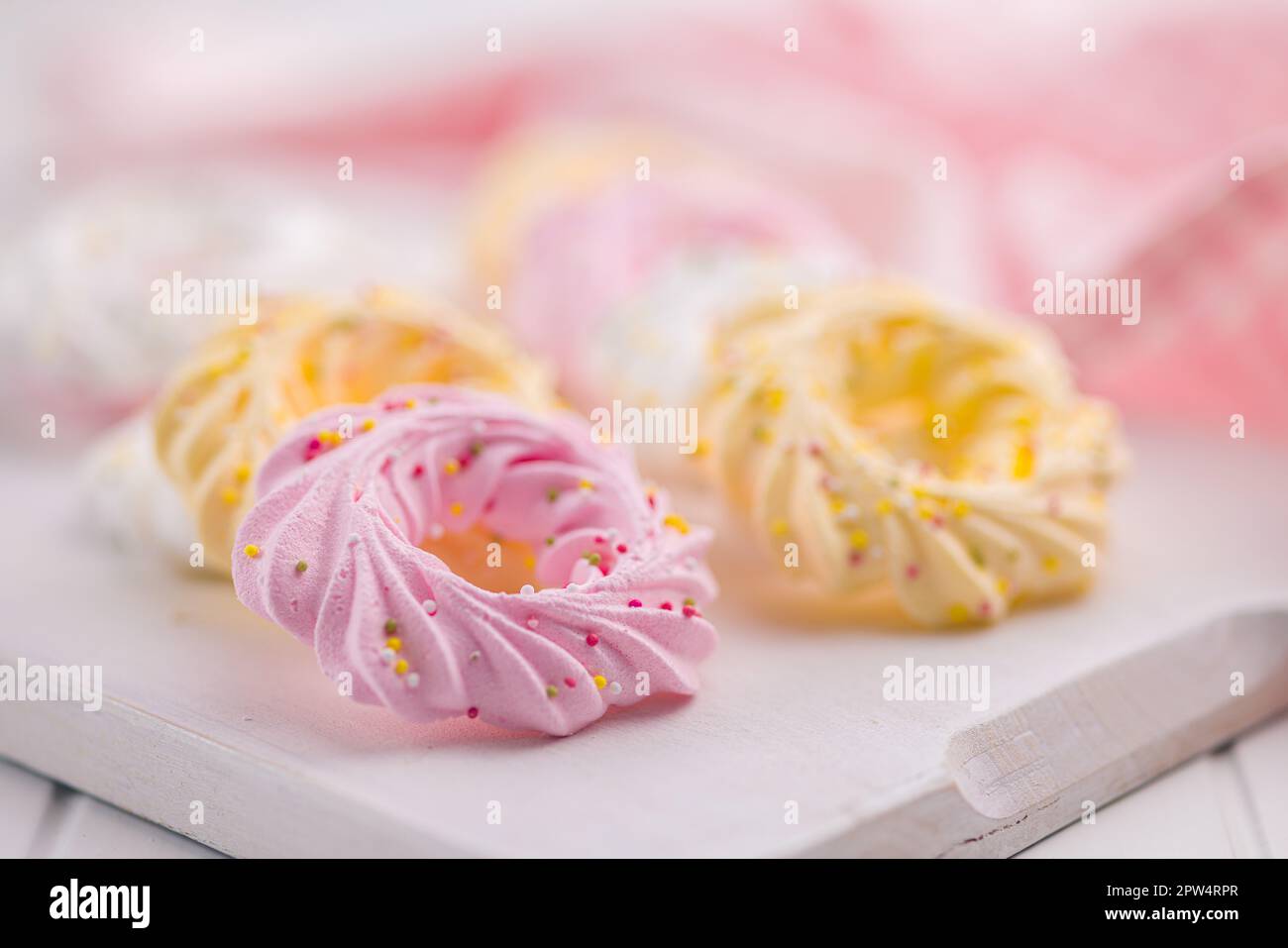 Different colors meringues with sprinkles on the white table Stock ...