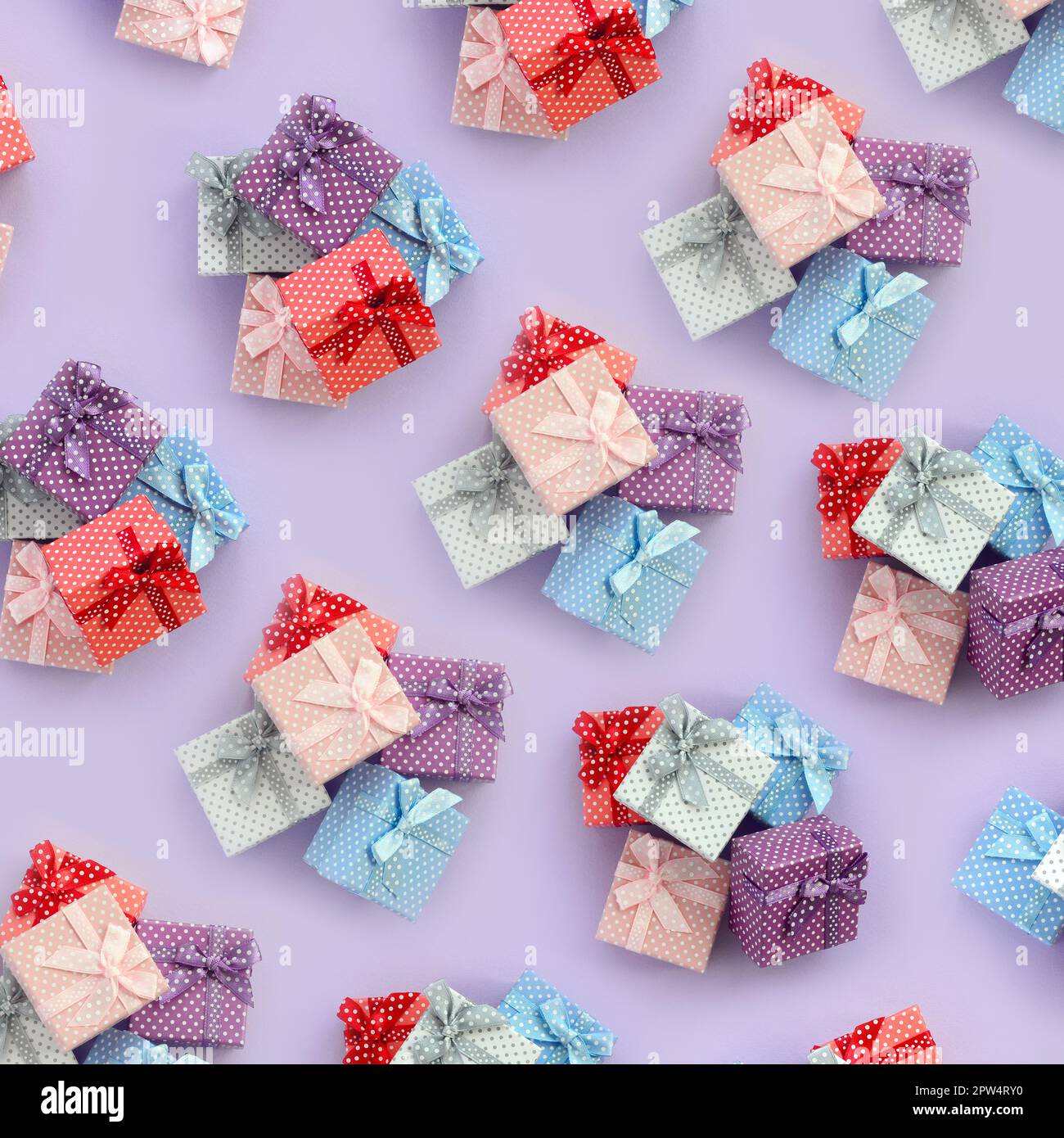 Small Gift Boxes Patterned Piles of a small colored gift boxes with ribbons lies on a violet ...