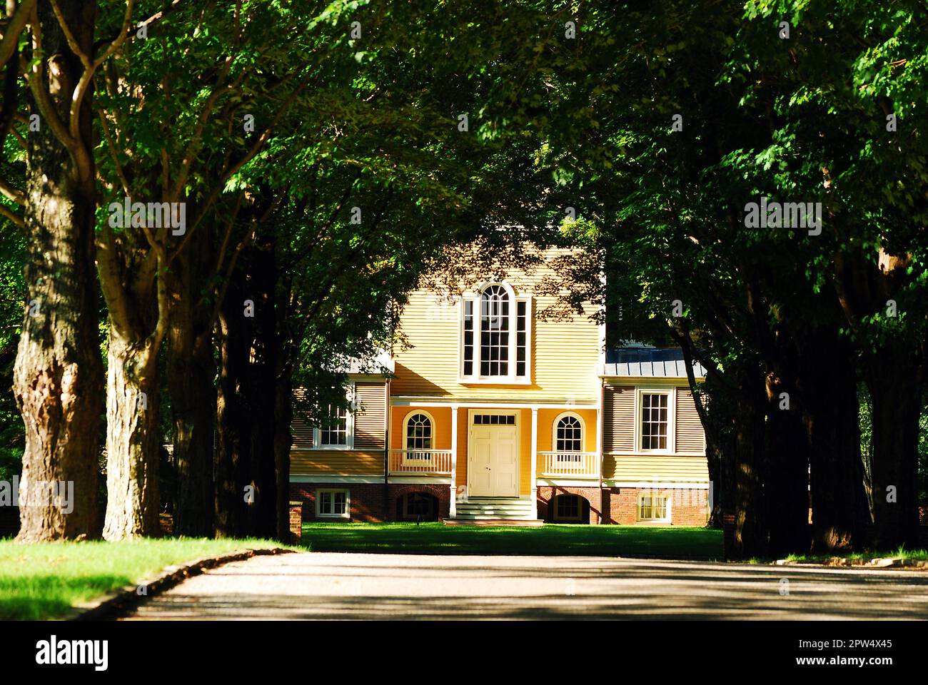 A tree lined driveway leads up to the yellow Boscobel Mansion, in Cold Spring, one of the many manors in the Hudson Valley Stock Photo