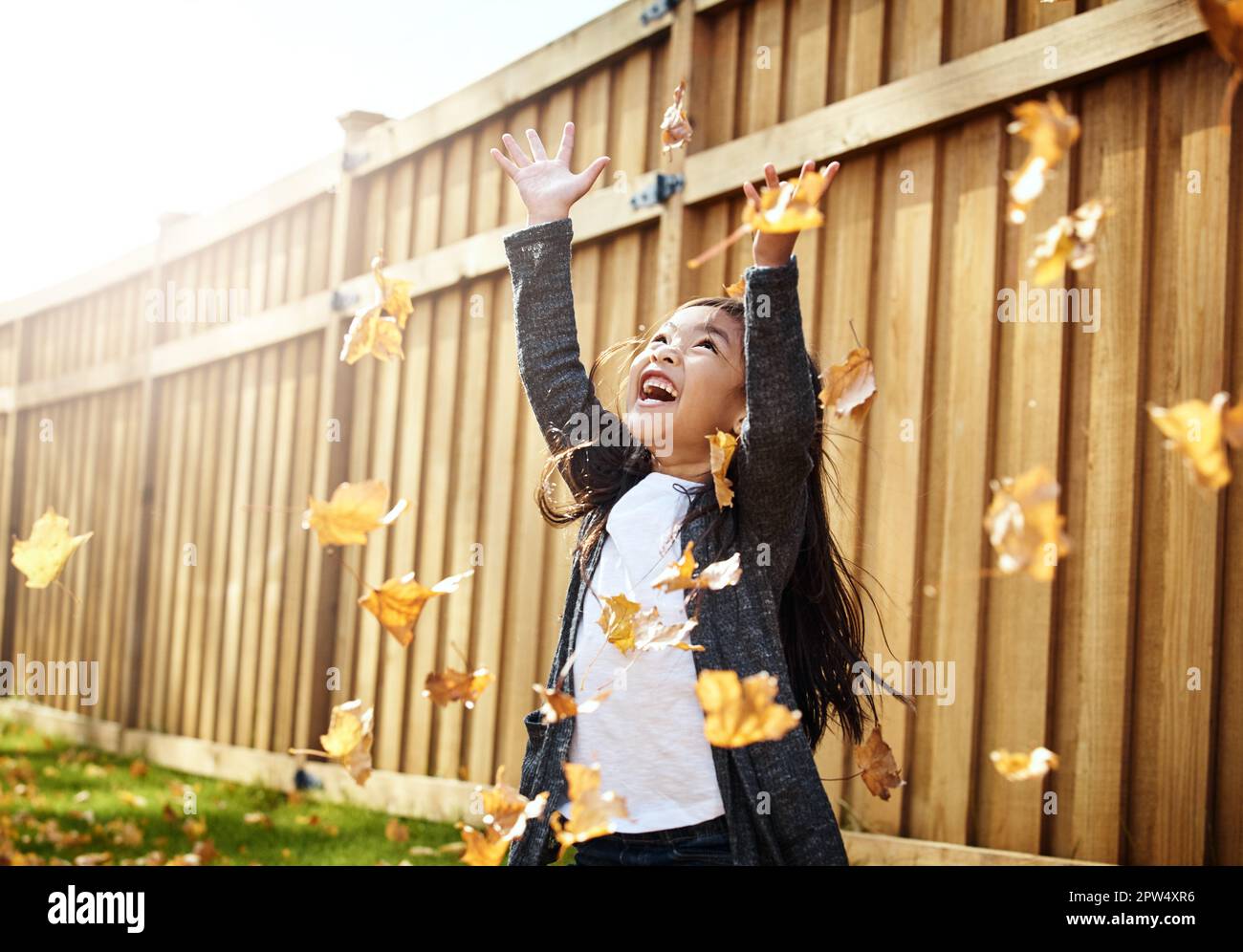 And the leaves came tumbling down. an adorable little girl enjoying an ...