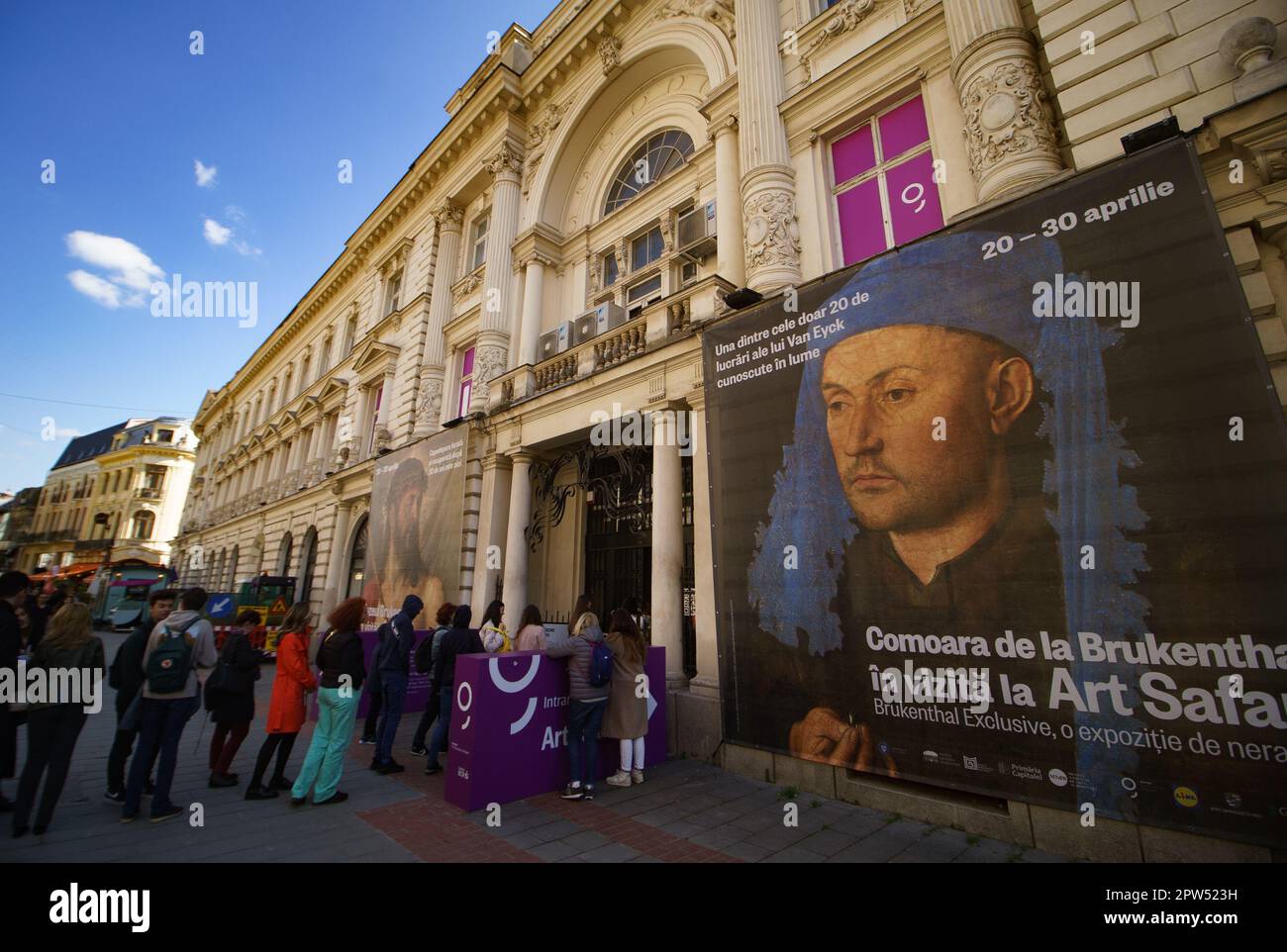 Bucharest, Romania. 28th Apr, 2023: People queue in line in front of Dacia Palace where Art Safari Bucharest and Brukenthal National Museum exhibit the paintings Portrait of a Man with a Blue Chaperon by Jan van Eyck and Ecce Homo by Tiziano Vecelli, the only painting by Titian that Romania owns, stolen in 1968 and recovered after 30 years in 1998. Credit: Lucian Alecu/Alamy Live News Stock Photo