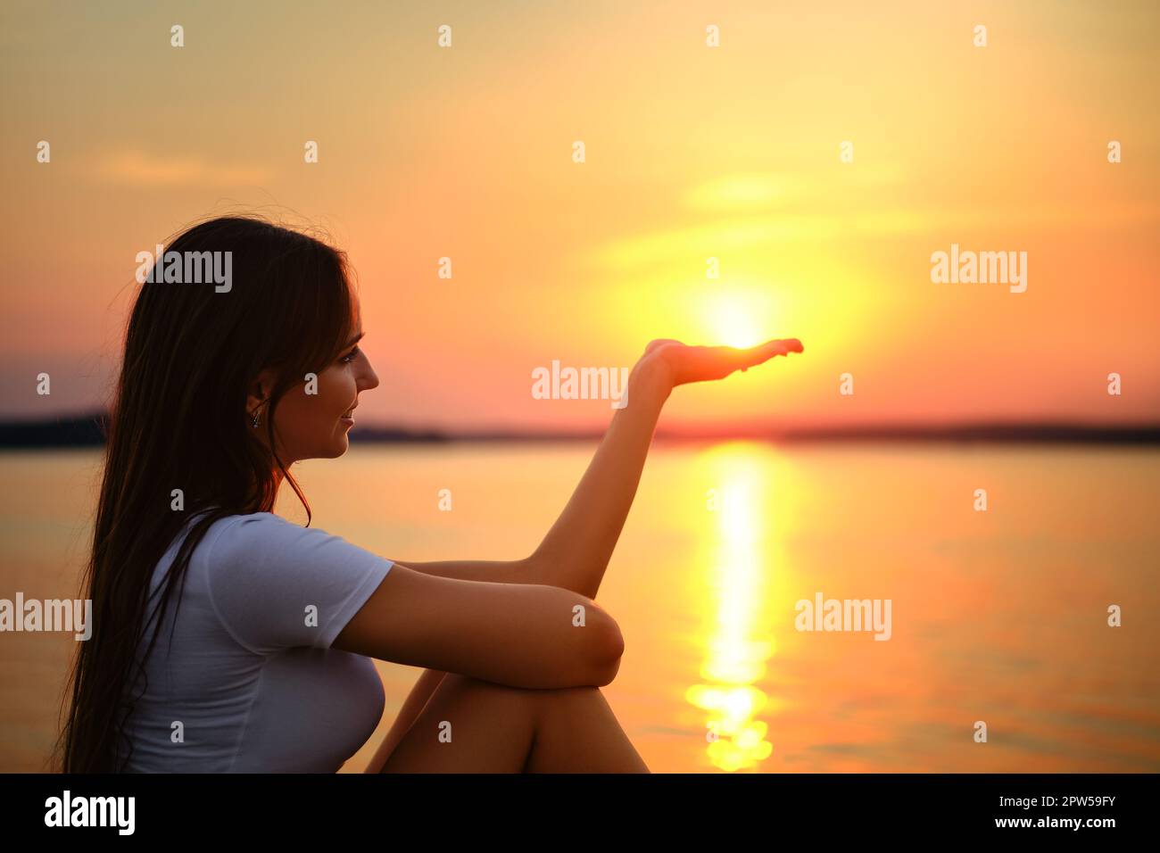 Childish woman holds the sun on palm of her hand Stock Photo - Alamy