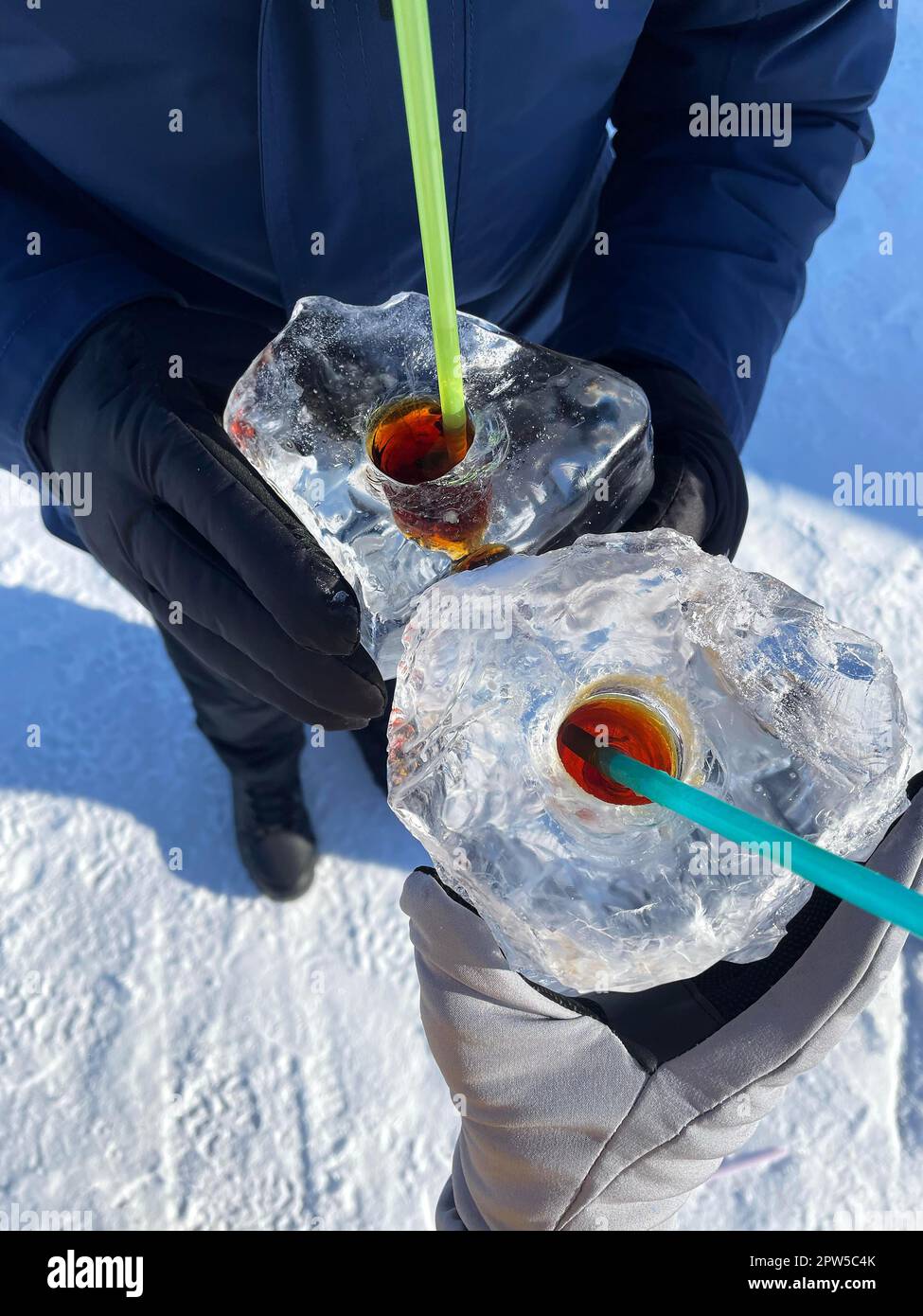 Baikal Ice Bar: man and woman drinking strong alcohol from ice cubes with hole. Popular tourist attraction during winter time aka Baikal Kiss Stock Photo
