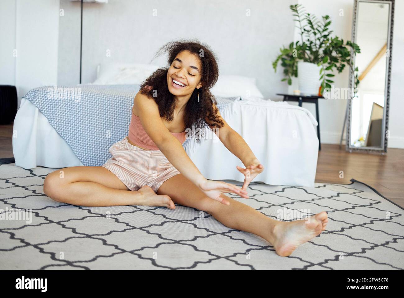 Cute african woman doing yoga at home in the morning. Healthy lifestyle and mindfulness concept Stock Photo