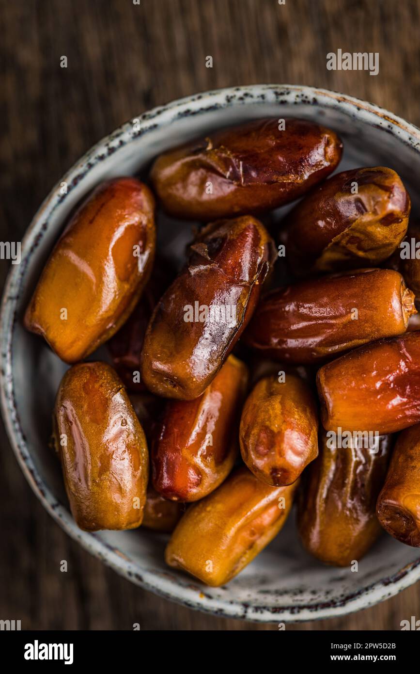 Dried dates fruit in the bowl. Top view Stock Photo - Alamy